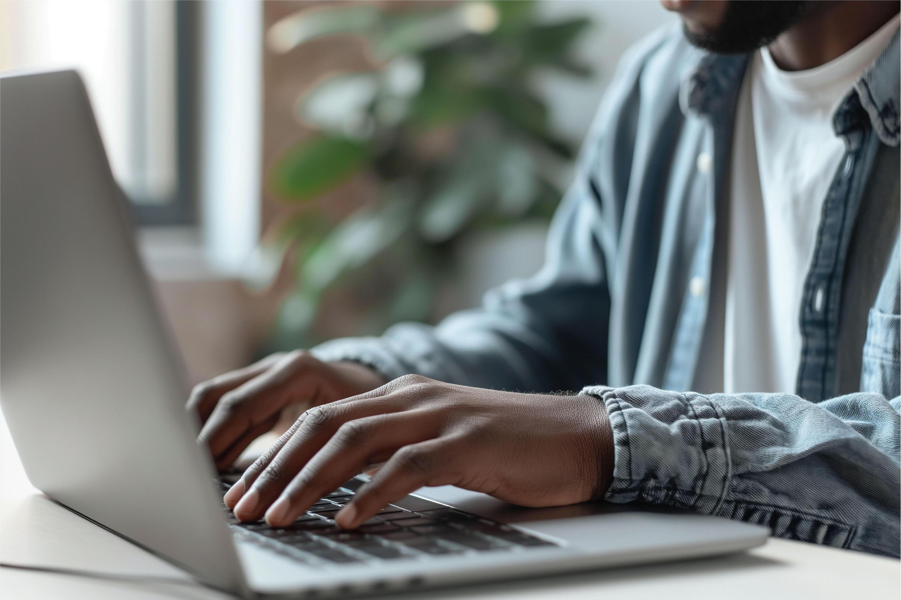 Portrait of happy arab freelancer man sitting at desk with laptop computer at home office Stock Free