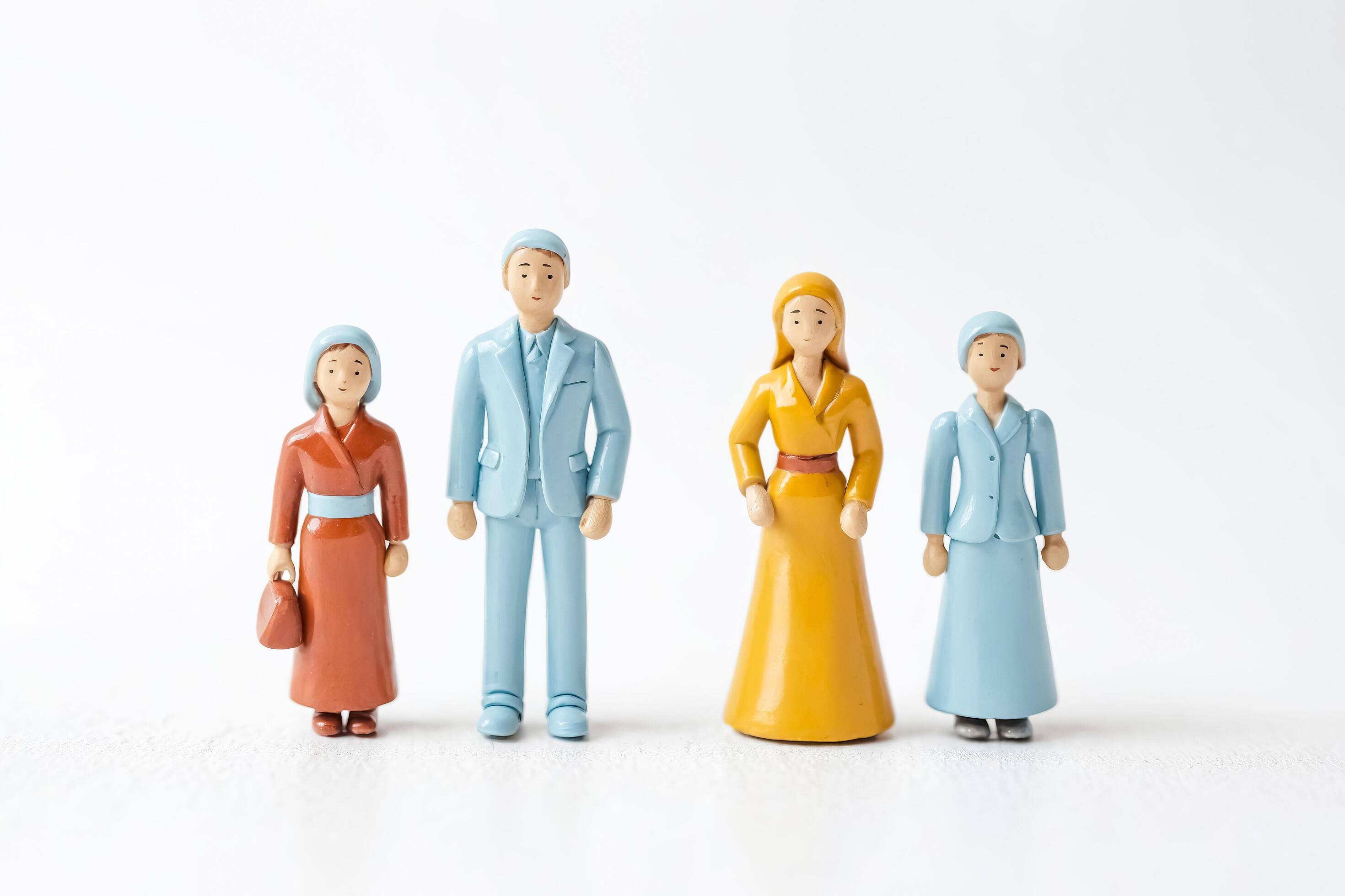 Family of four figurines standing in a row Stock Free