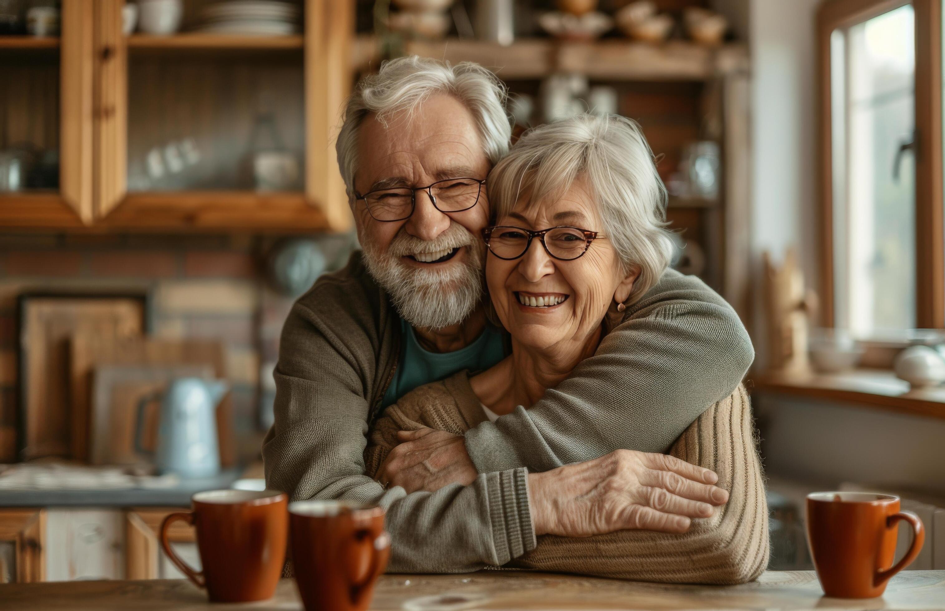 Smiling Senior Couple Enjoying Coffee Together In Their Home Kitchen Stock Free