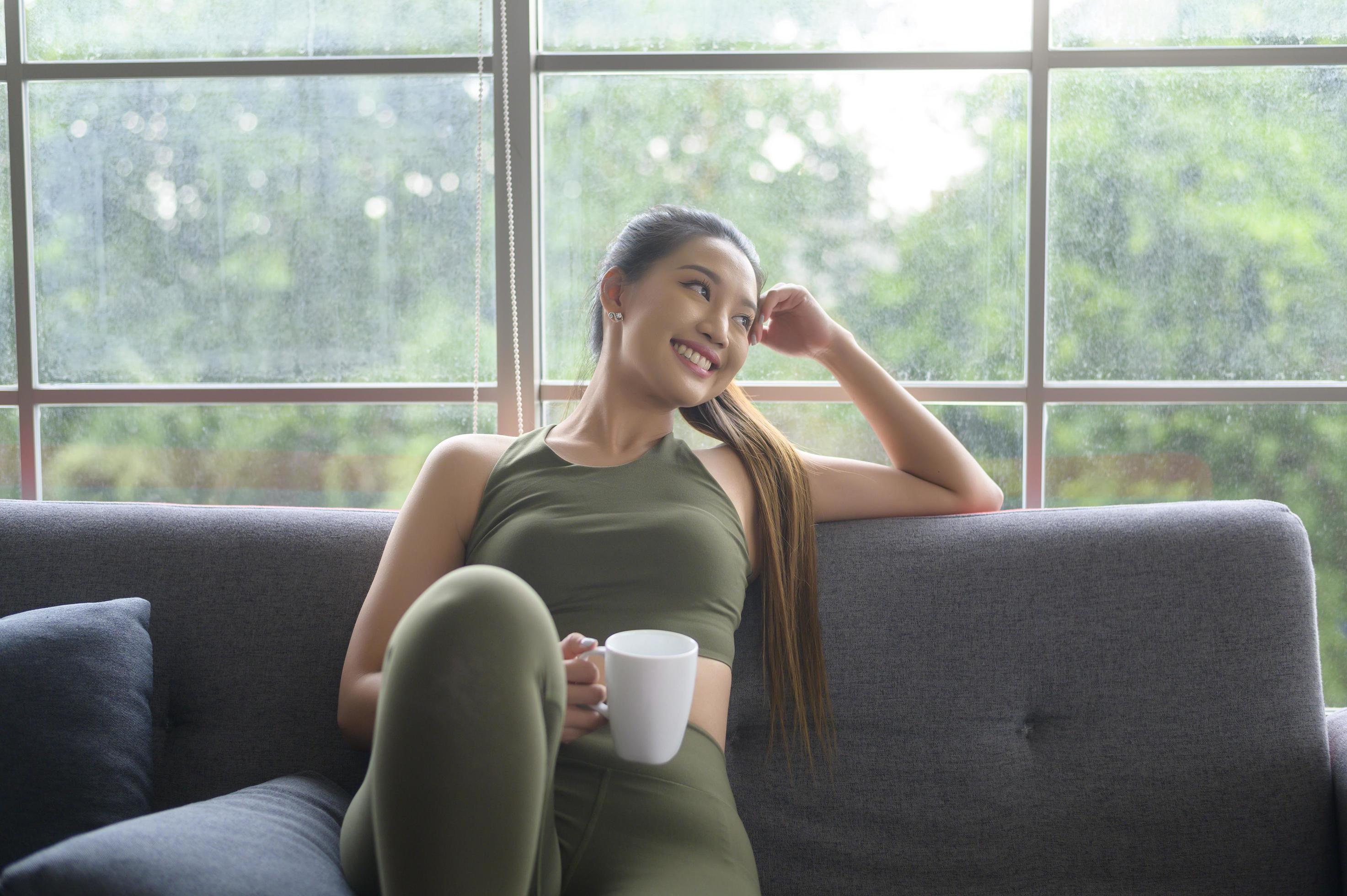 Young fitness woman in sportswear having a cup of coffee after exercising at home, Healthy and Lifestyles. Stock Free