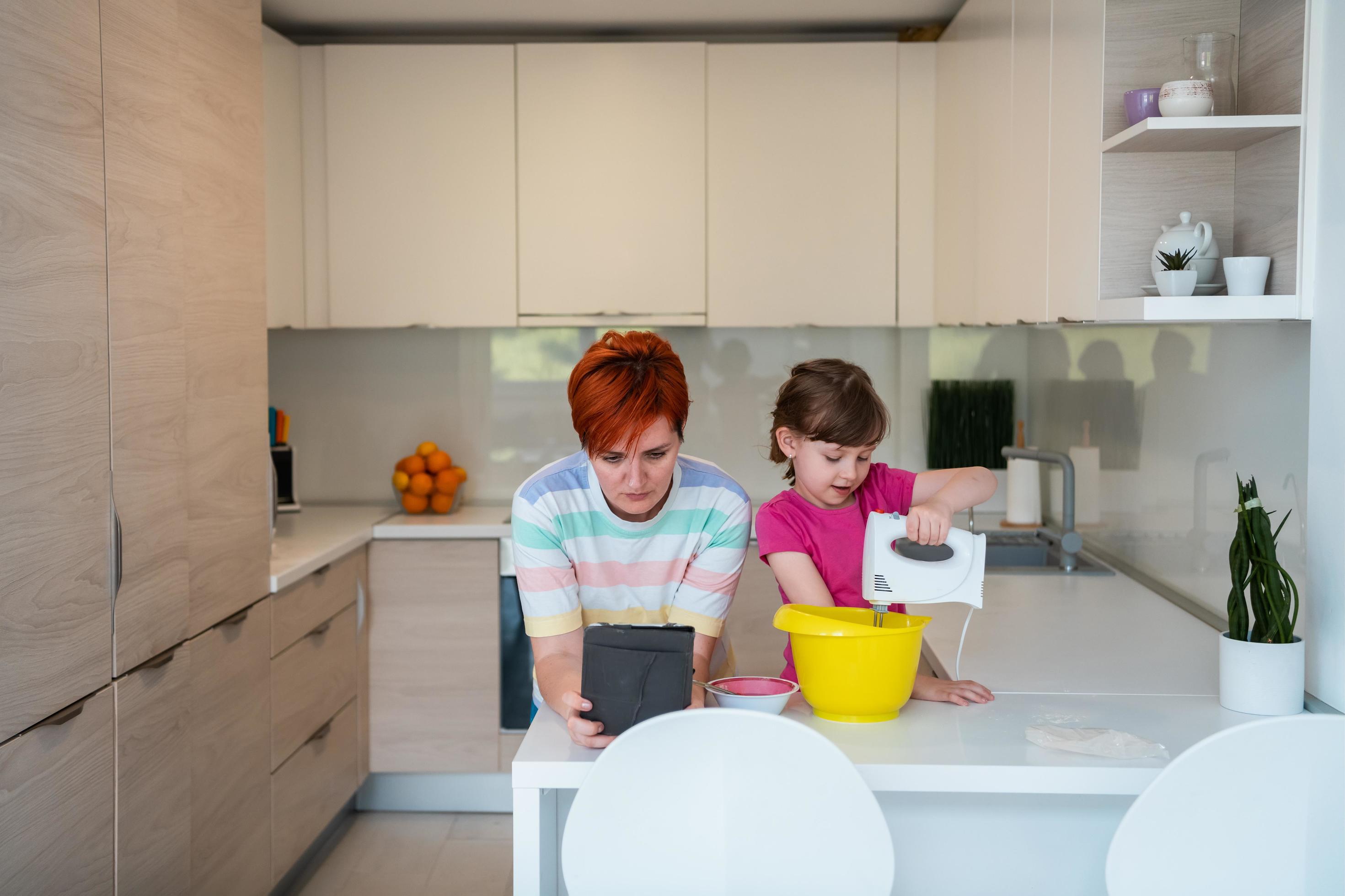 little girl and mom making tastz cake in kithen family having fun at home Stock Free