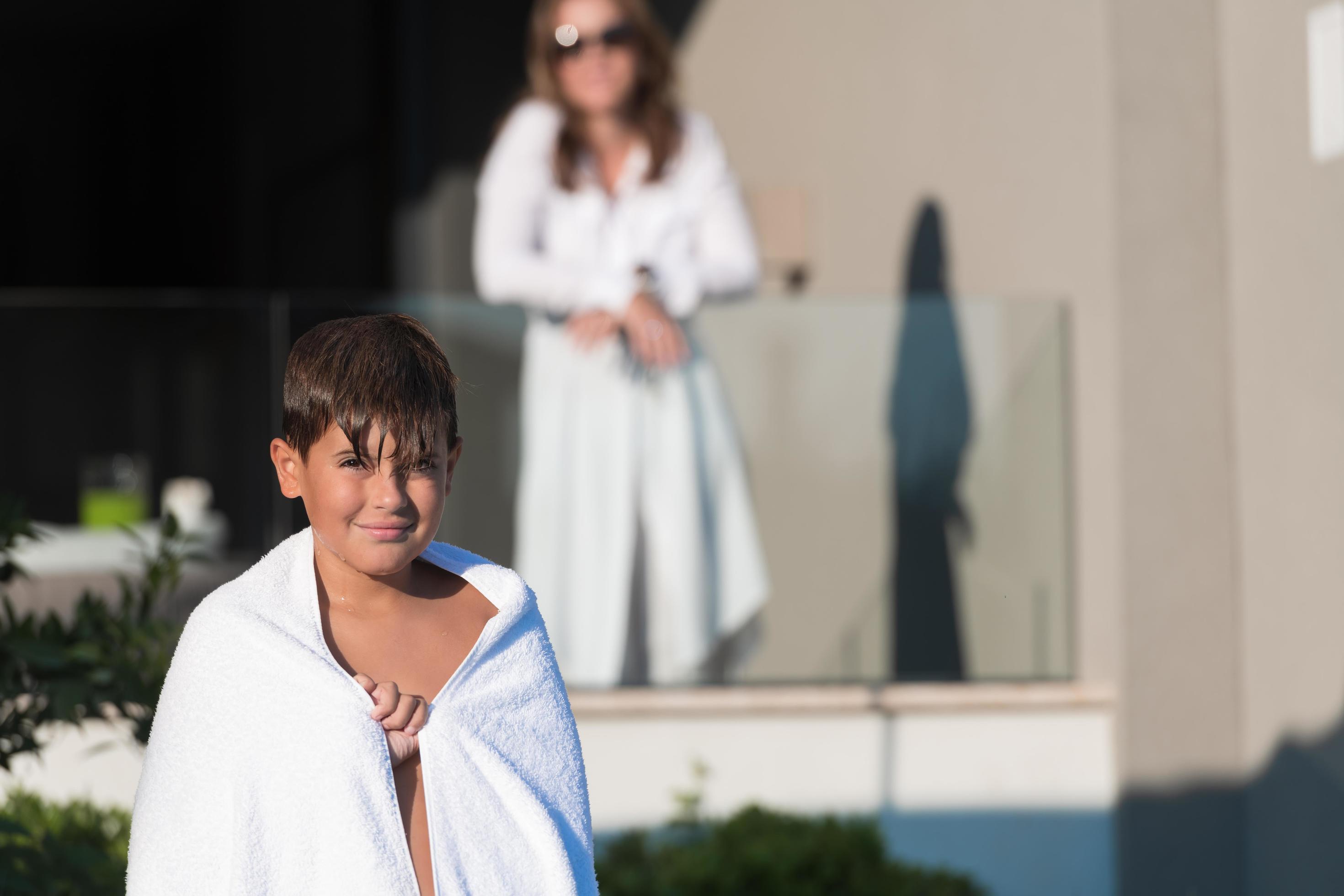 The boy enjoys a summer day swimming in the pool. The concept of a family vacation. Selective focus Stock Free