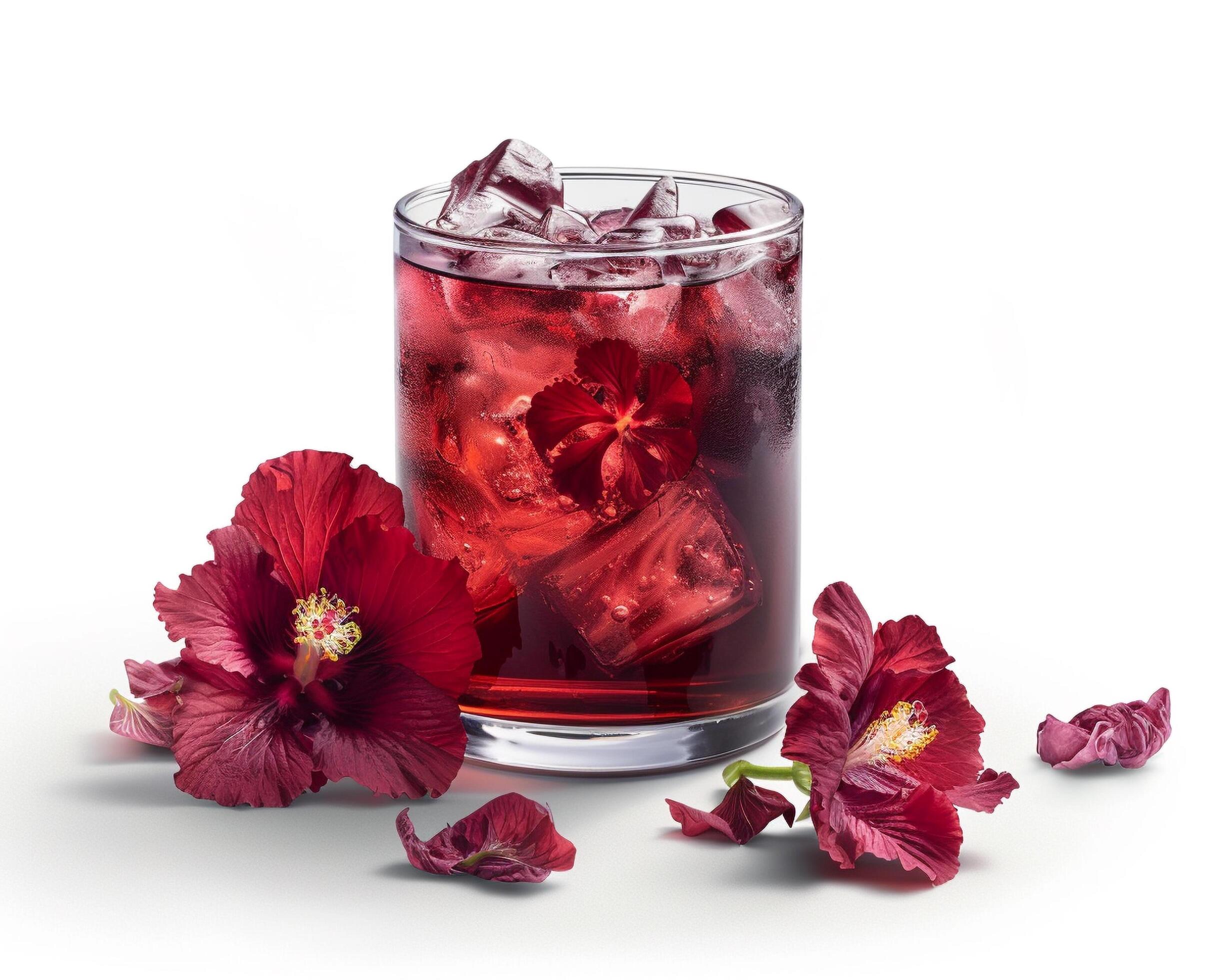 a glass of red drink with ice and flowers Stock Free