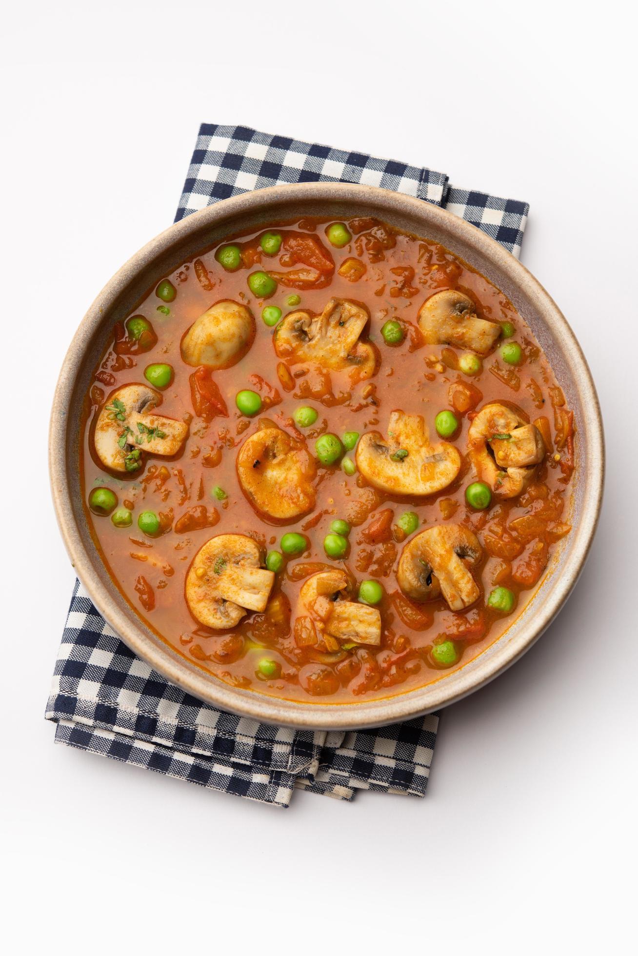 Mushroom and Pea Curry with Roasted Garlic, Indian food served in a bowl Stock Free