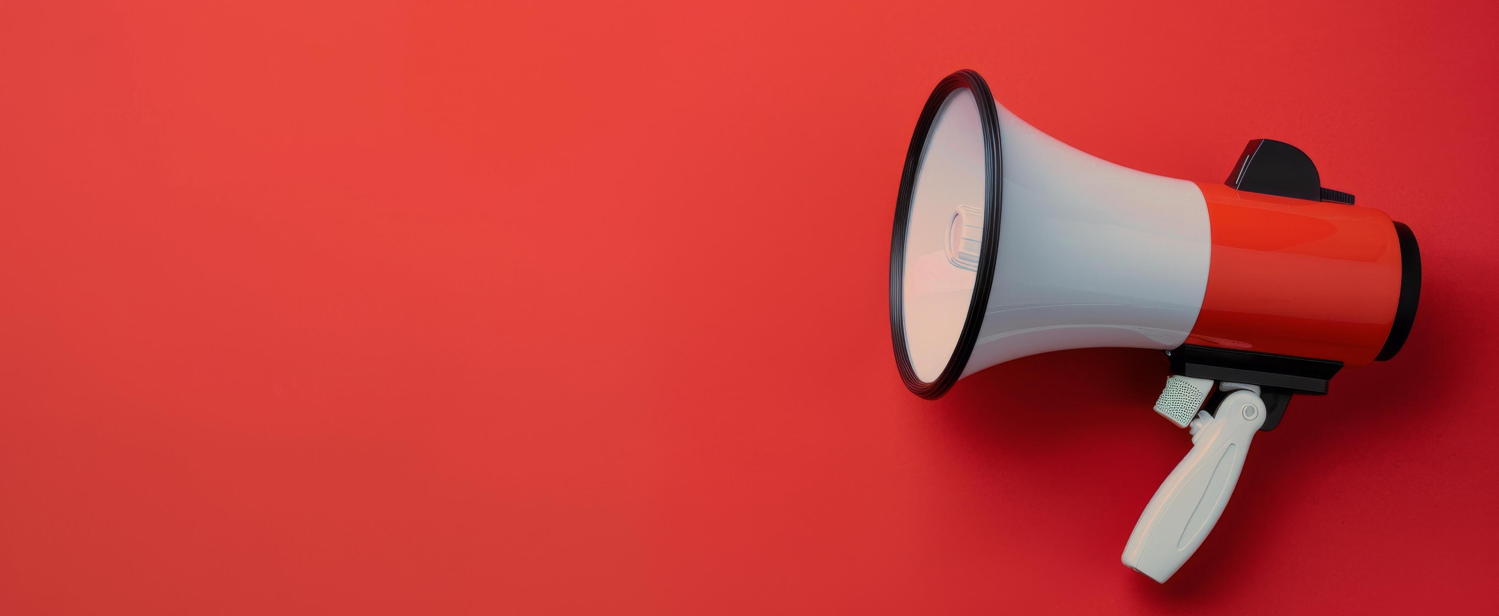 Megaphone Positioned on Red Background for Announcements and Communication Stock Free