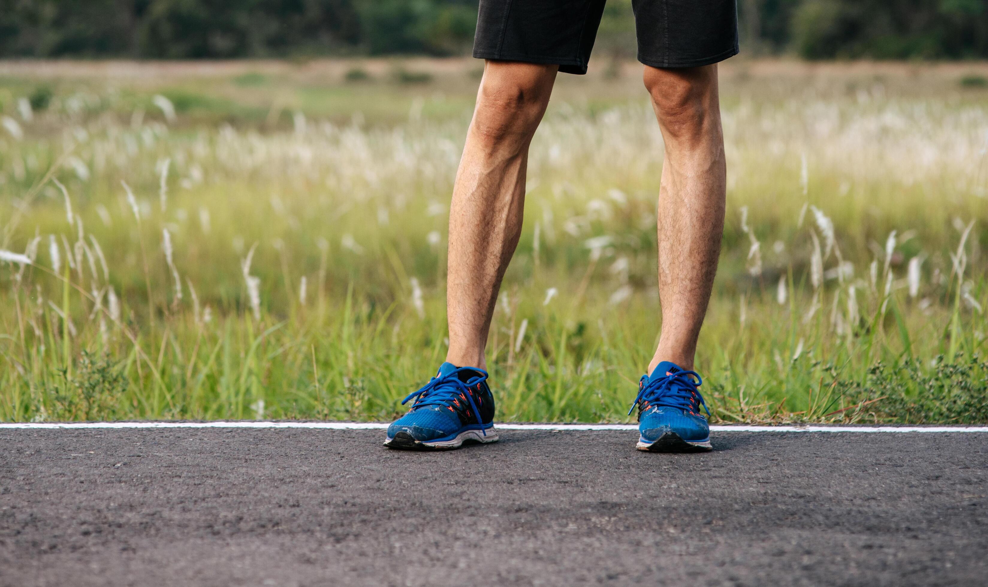 Runner man feet running on road closeup on shoe. Sports healthy lifestyle concept. Stock Free