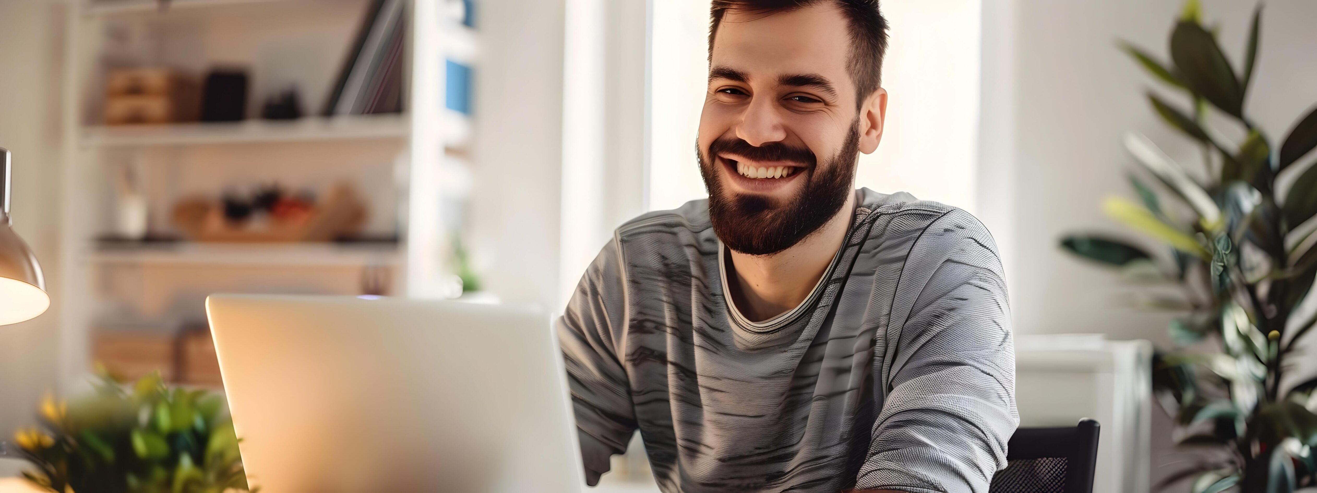 Smiling Young Web Developer Working Remotely on Laptop at Home Office Stock Free