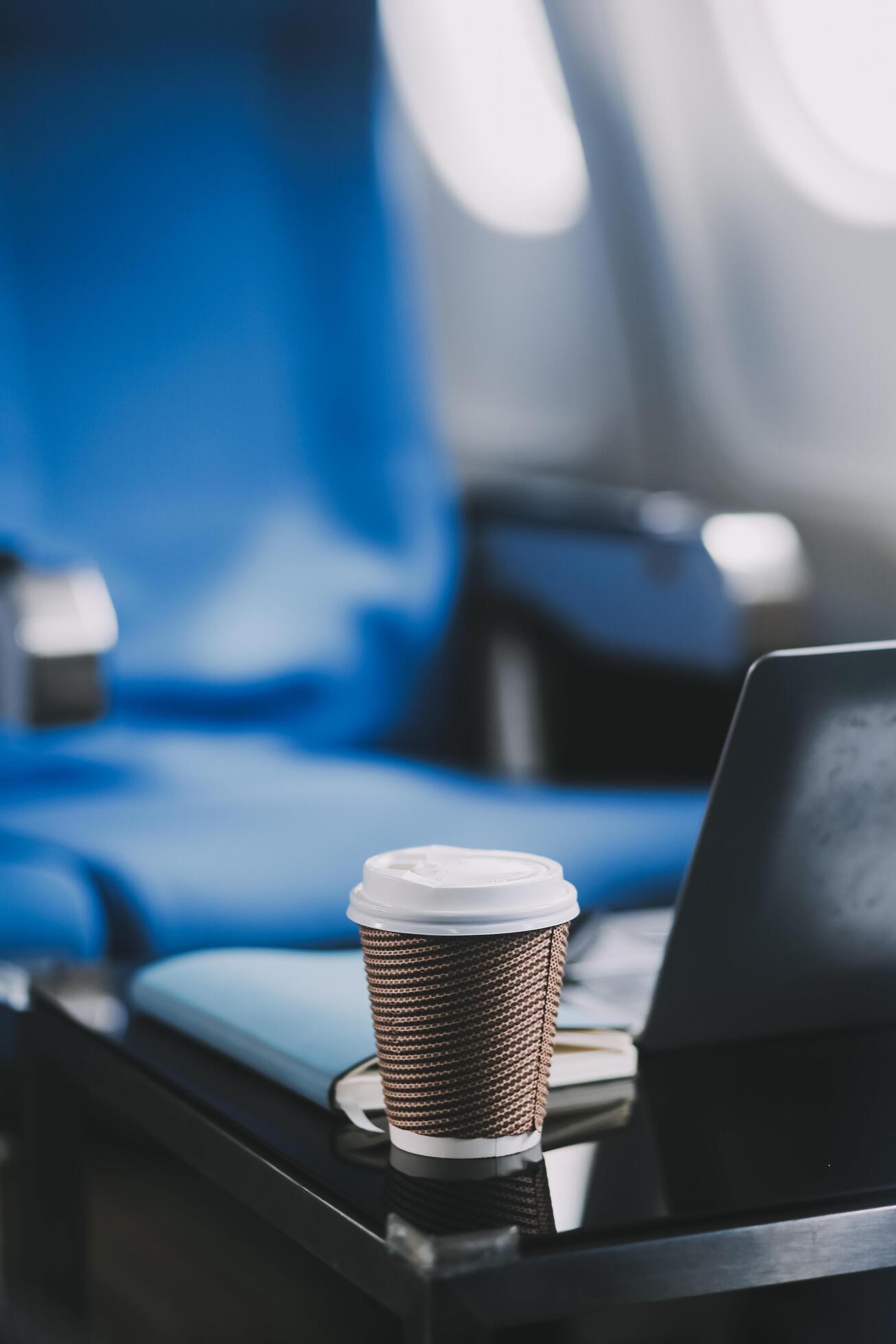 Asian businessman enjoying enjoys a coffee comfortable flight while sitting in the airplane cabin, Passengers near the window. Stock Free