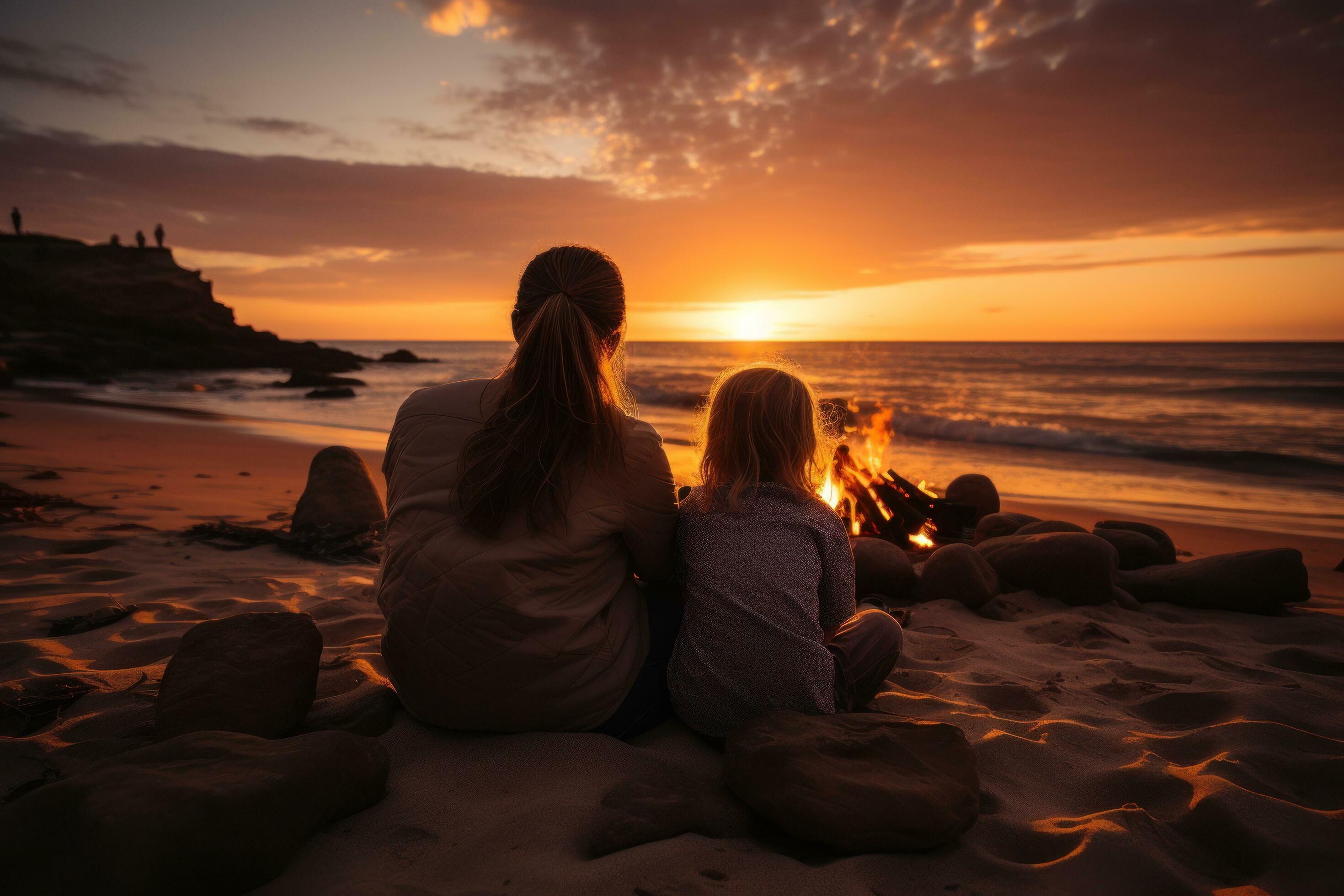 Loving family cuddling and watching the sunset on the beach Stock Free