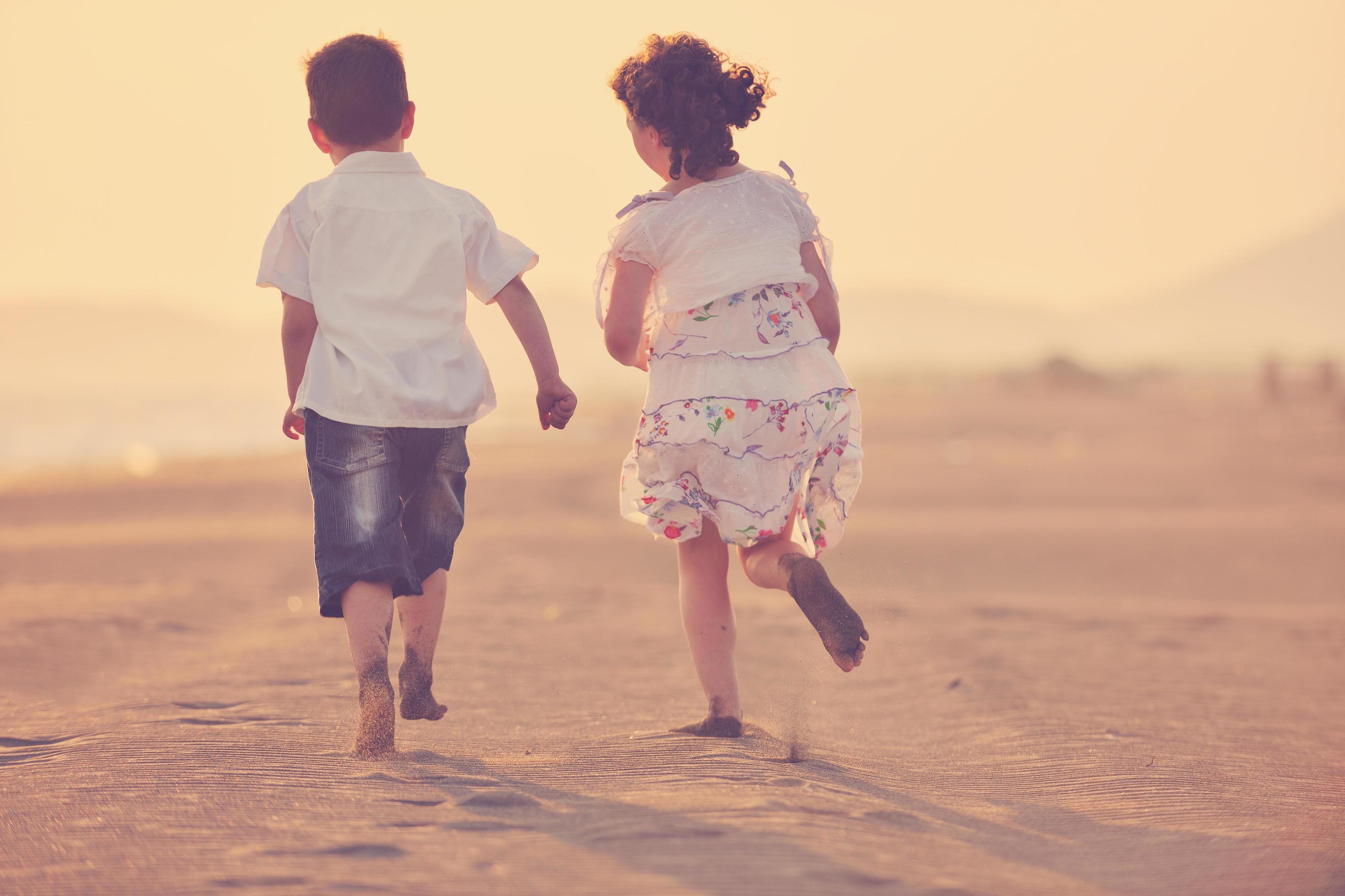 happy young family have fun on beach at sunset Stock Free