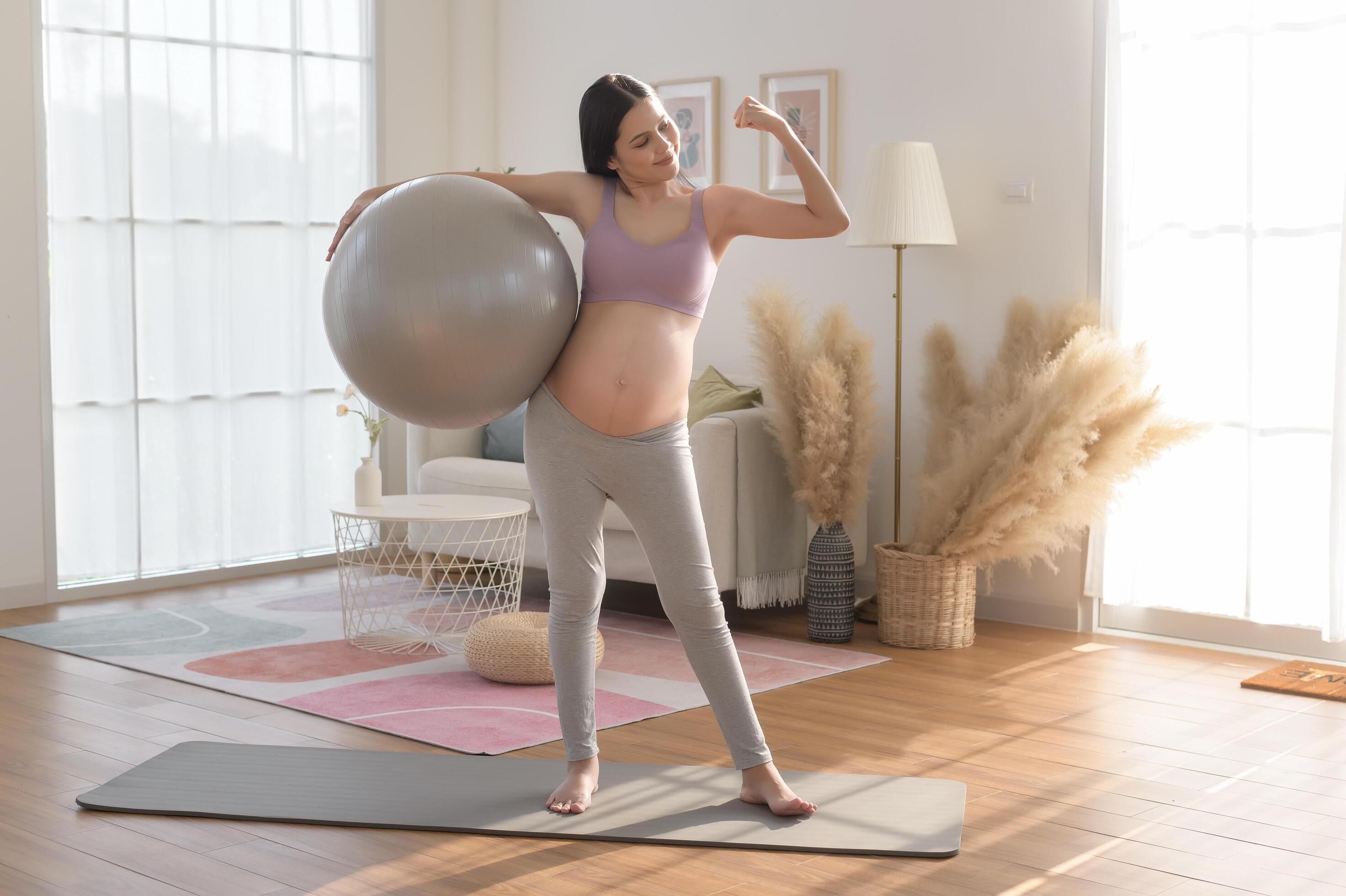 Healthy pregnant woman exercising and doing prenatal yoga, meditation, working out, yoga, pregnancy concept. Stock Free