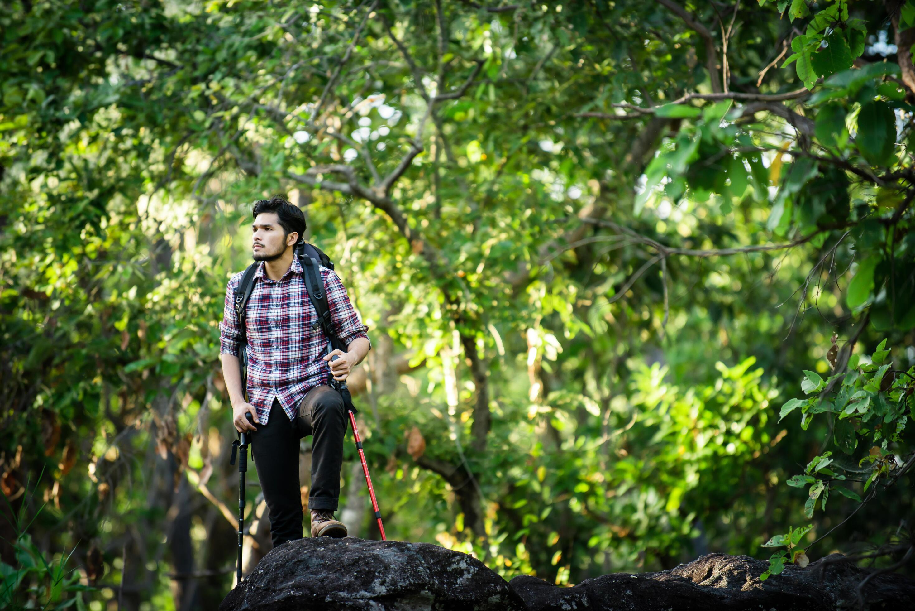 Young hiker relaxing on top of a mountain, Enjoy nature and adventure. Stock Free