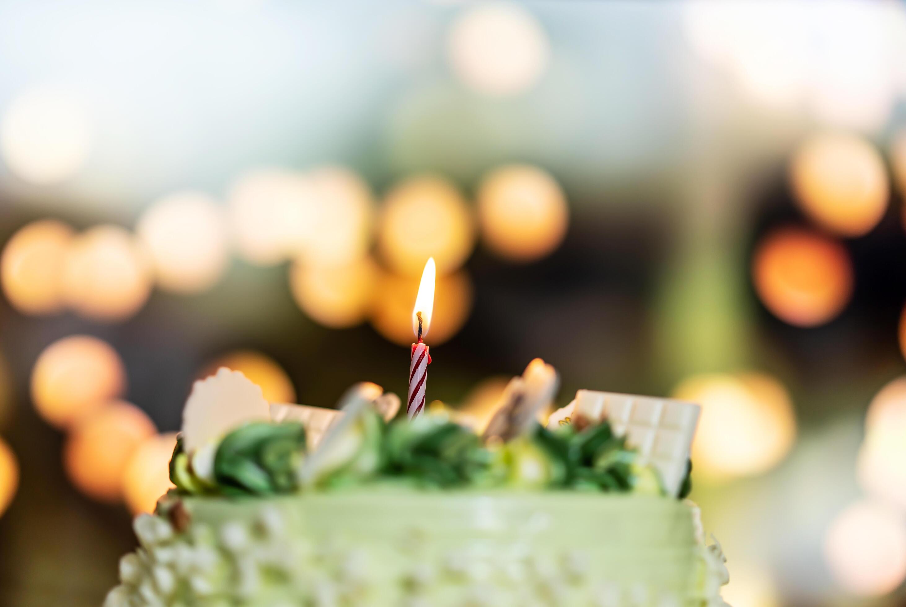 Happy birthday cake with candles on the background of bright lights bokeh. Stock Free