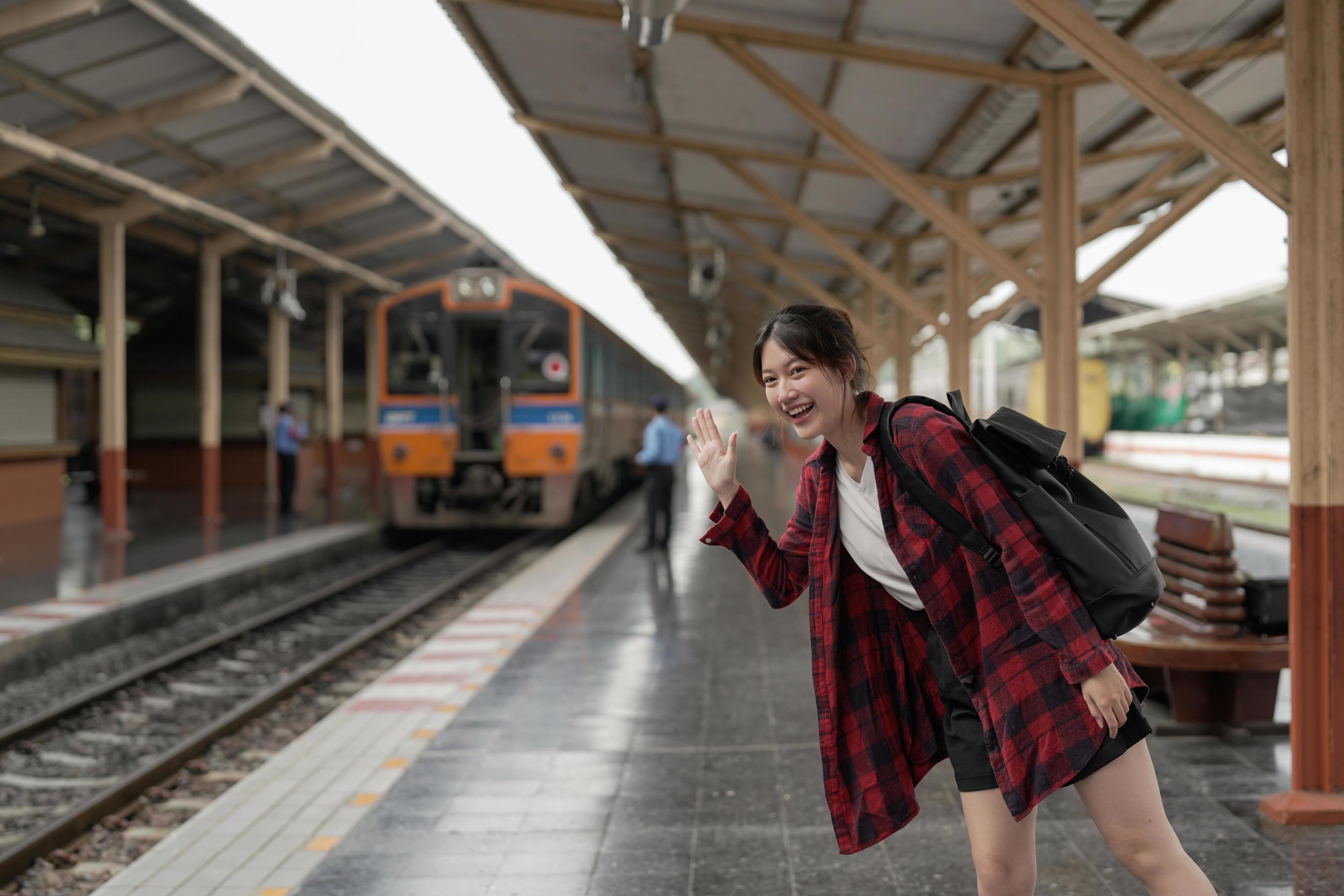 Happy asia woman traveller feeling happiness before go to travel at the train station, summer travel and lifestyle concept Stock Free