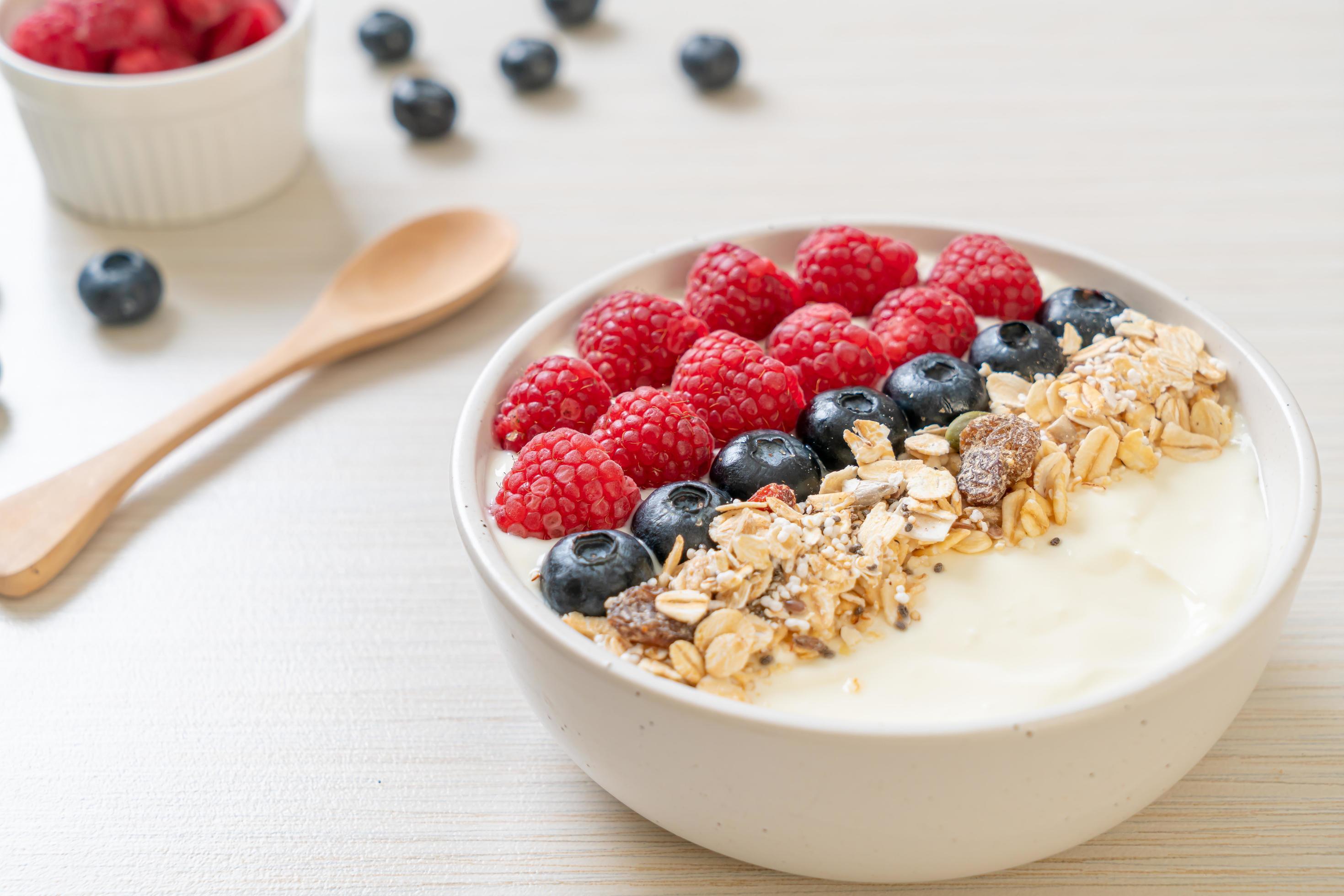 Homemade yogurt bowl with raspberry, blueberry and granola – healthy food style Stock Free