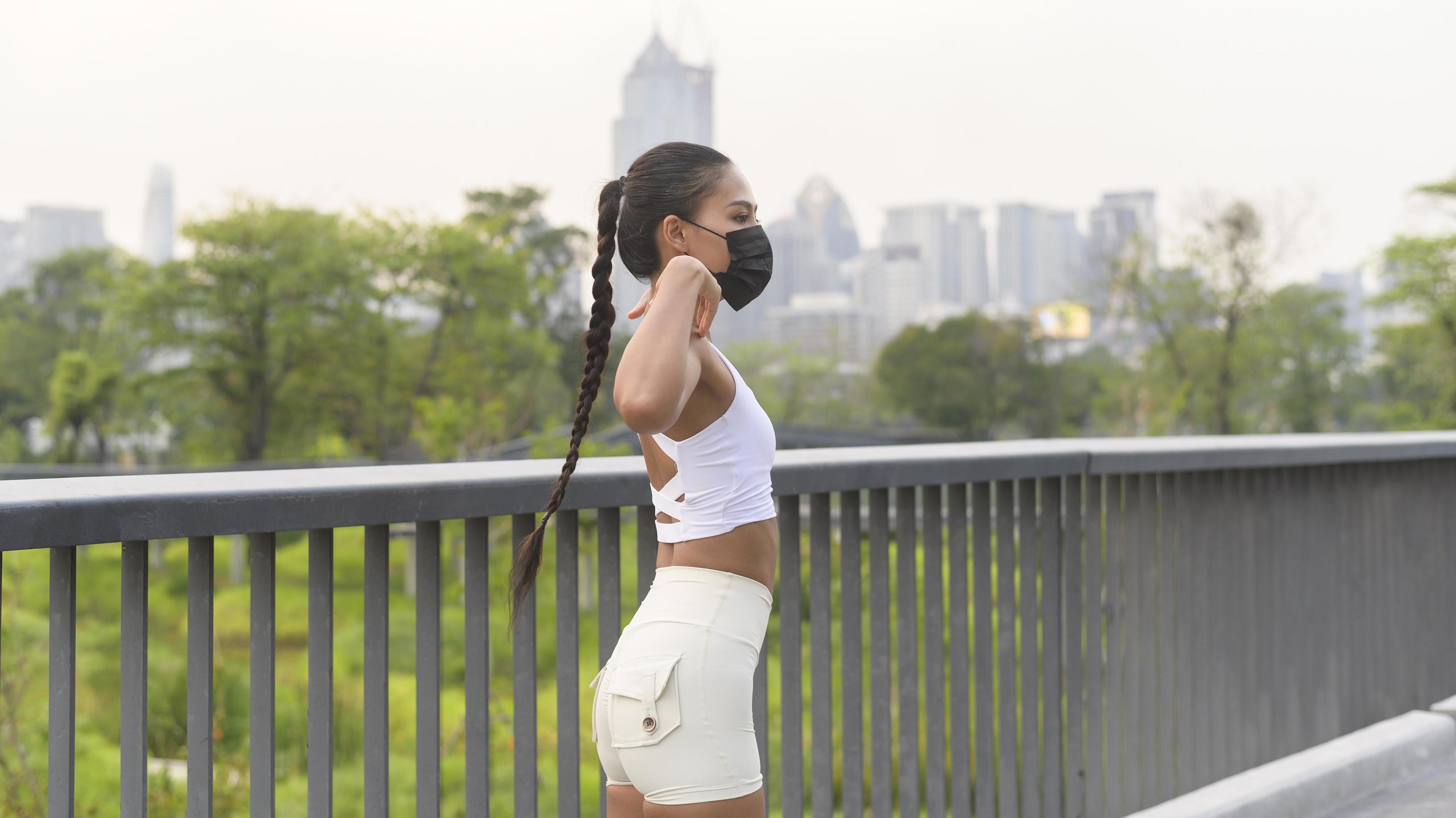 Young fitness woman in sportswear wearing face mask while exercise in city park, Health and Lifestyles. Stock Free