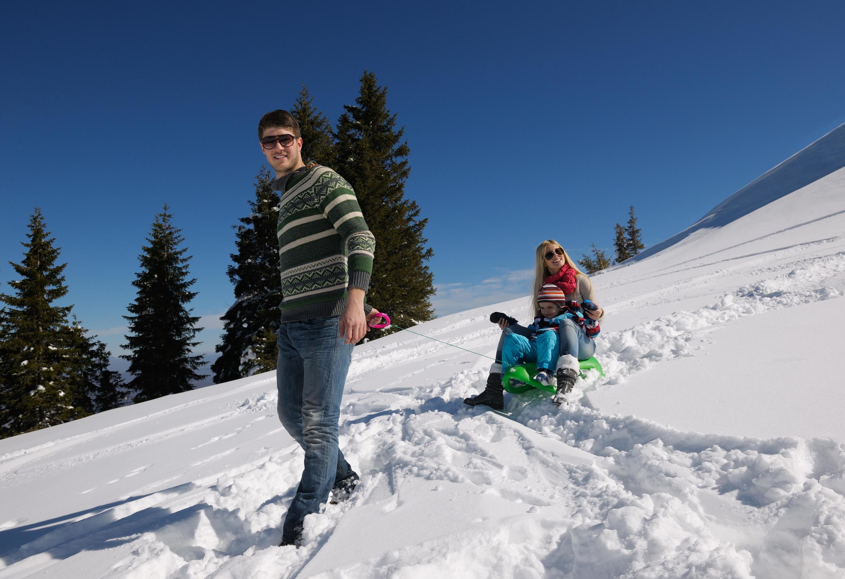 family having fun on fresh snow at winter vacation Stock Free