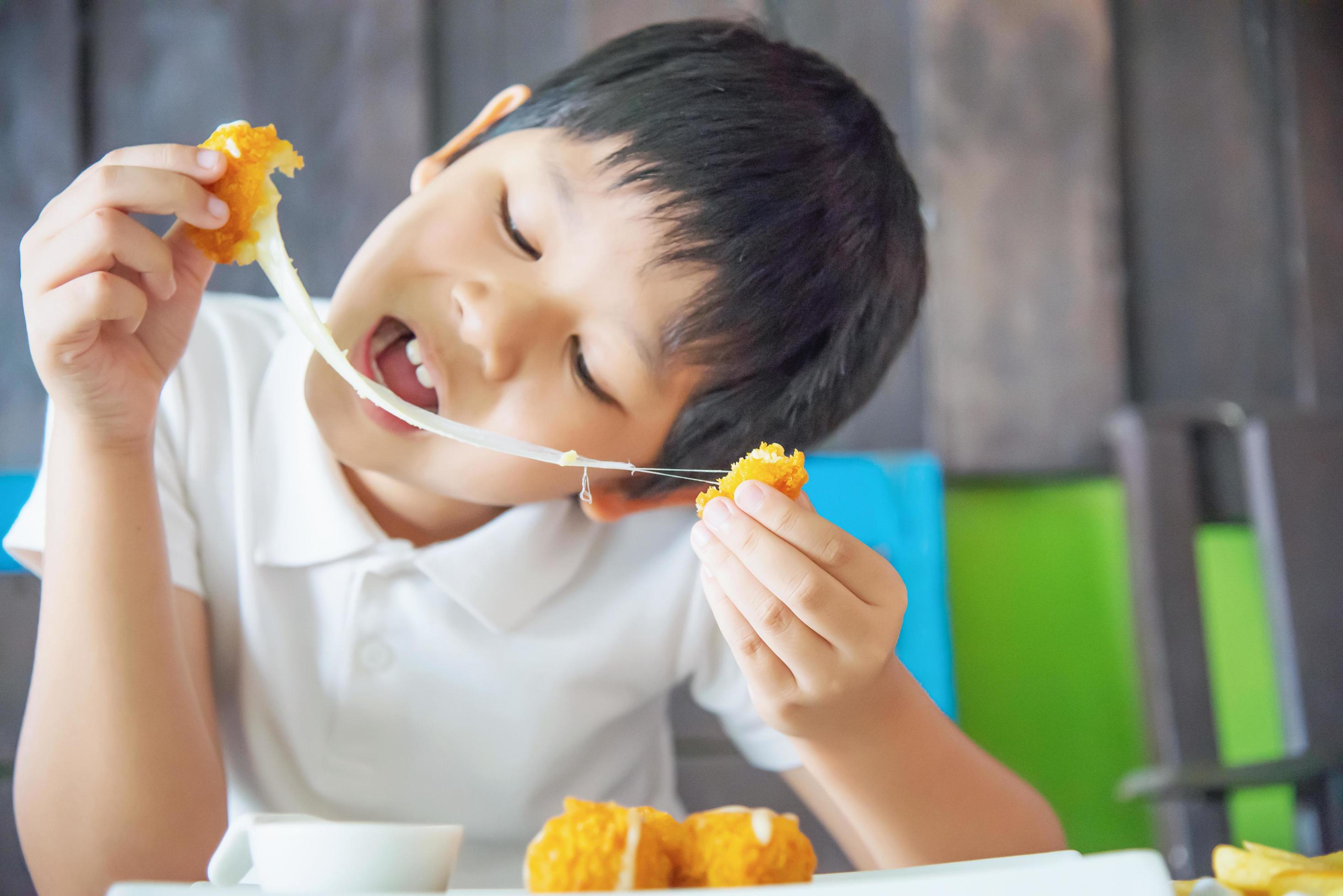 Boy ready to eat sticky stretch fried cheese ball – people and delicious cheese food concept Stock Free