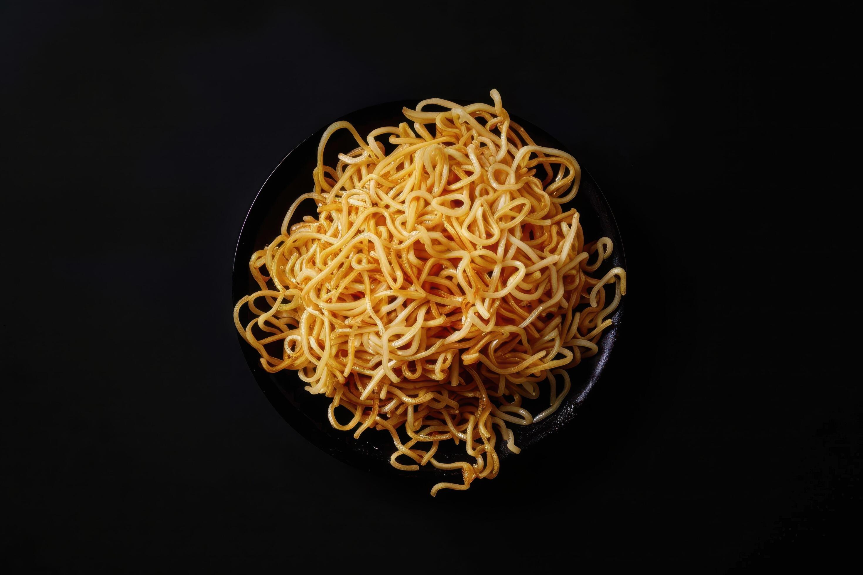 A Plate of Golden Noodles on a Black Background Stock Free