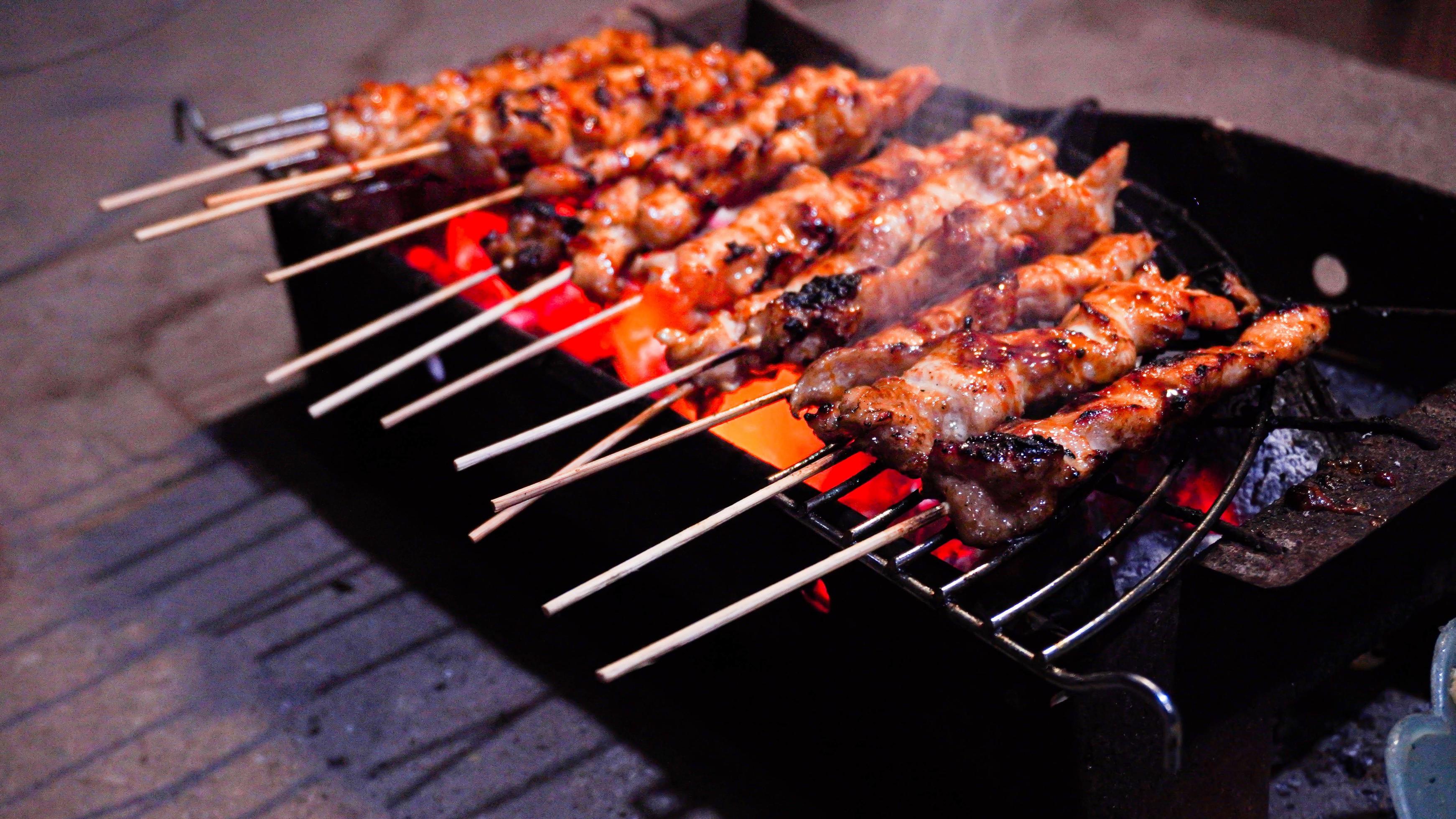 the process of making satay food, grilled over charcoal coals Stock Free