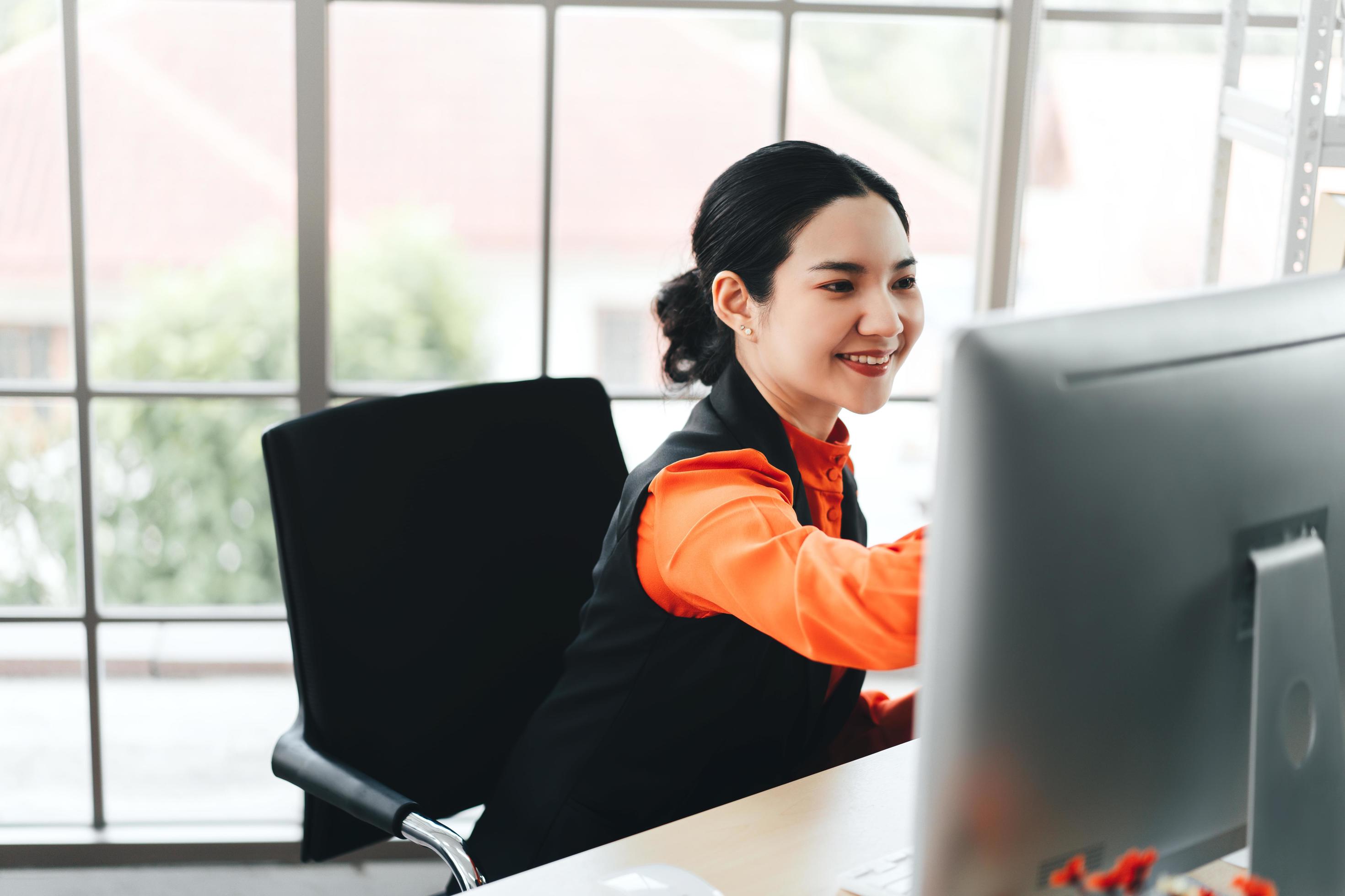 Business asian woman work with happy smile and concentration to job Stock Free