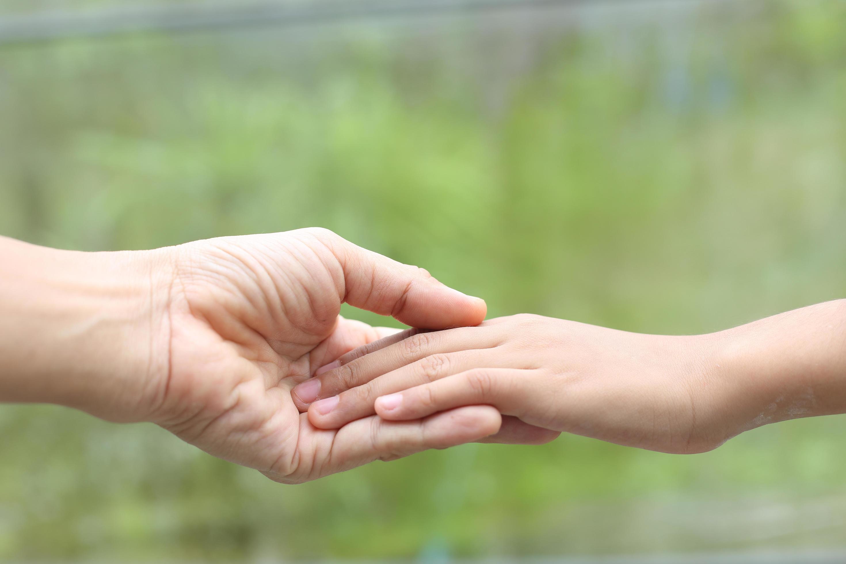 Family helping – Child hand put on mother hand with love and care Stock Free