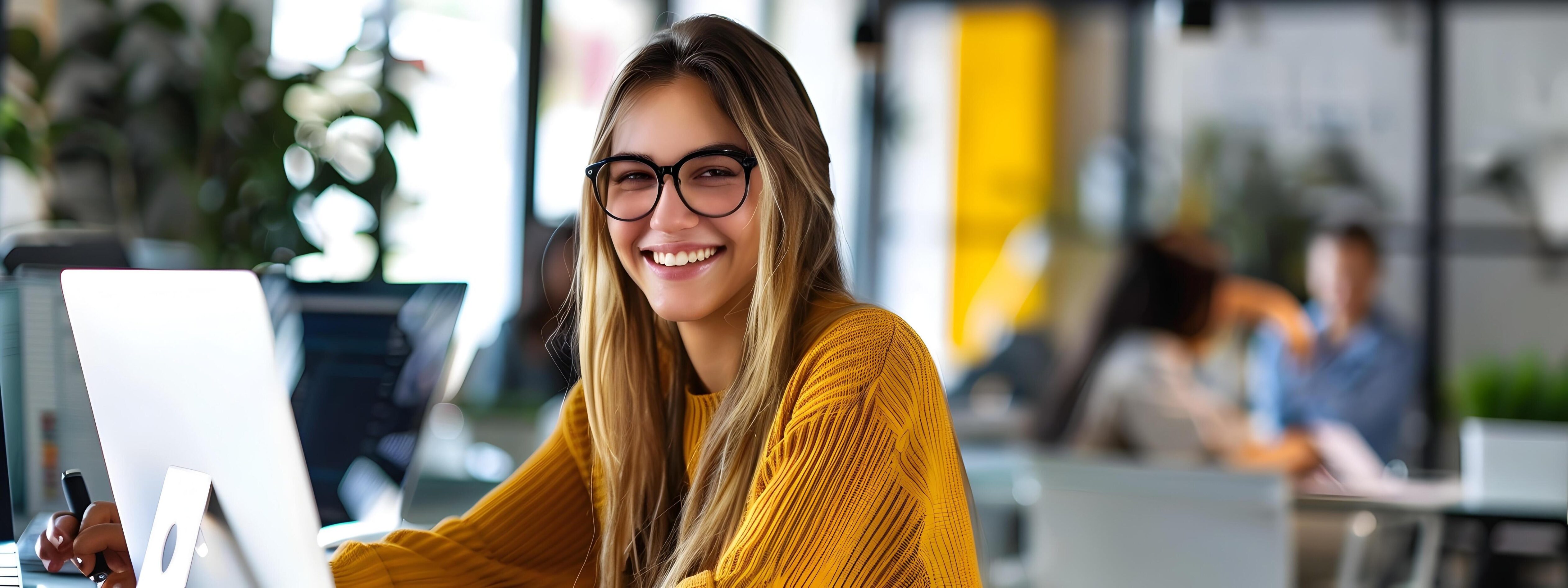 Young Smiling Woman Working on Computer in Office Environment Stock Free