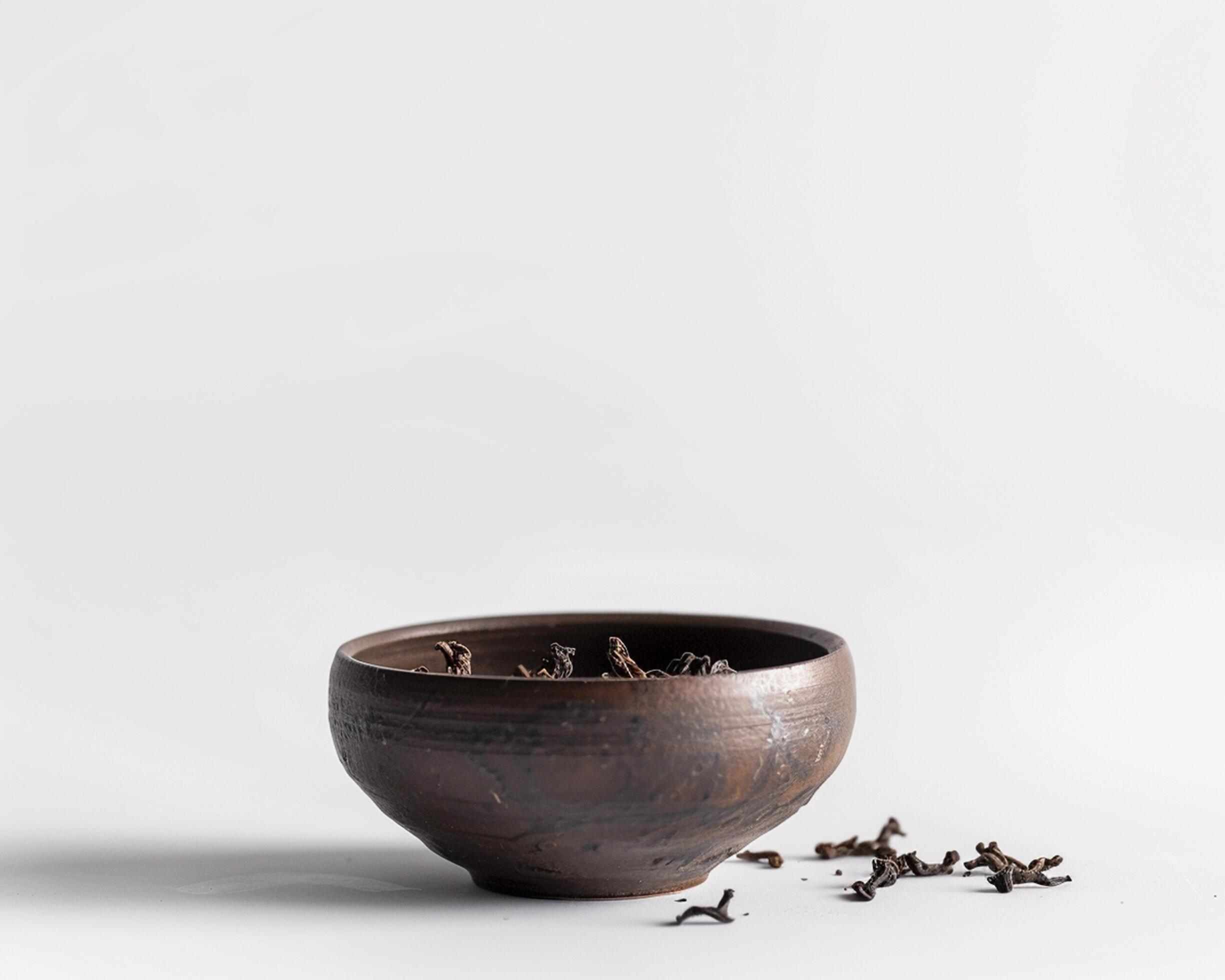 a brown bowl with a few pieces of dried fruit in it Stock Free