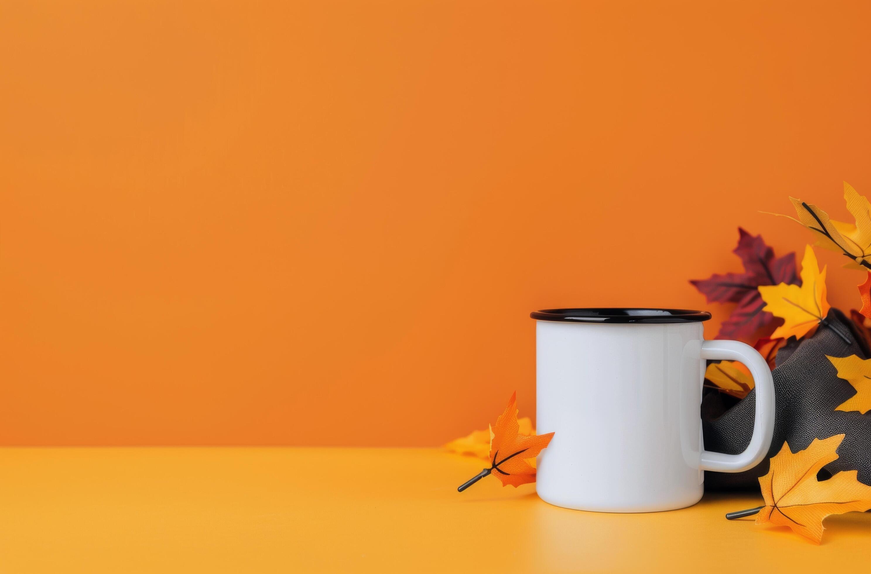 White Mug With Fall Leaves on Orange Background Stock Free