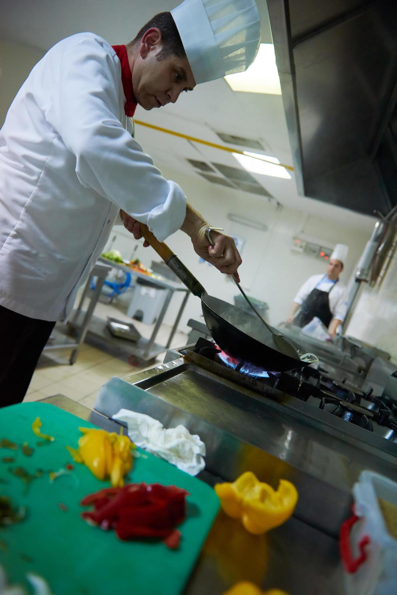 chef in hotel kitchen prepare food with fire Stock Free