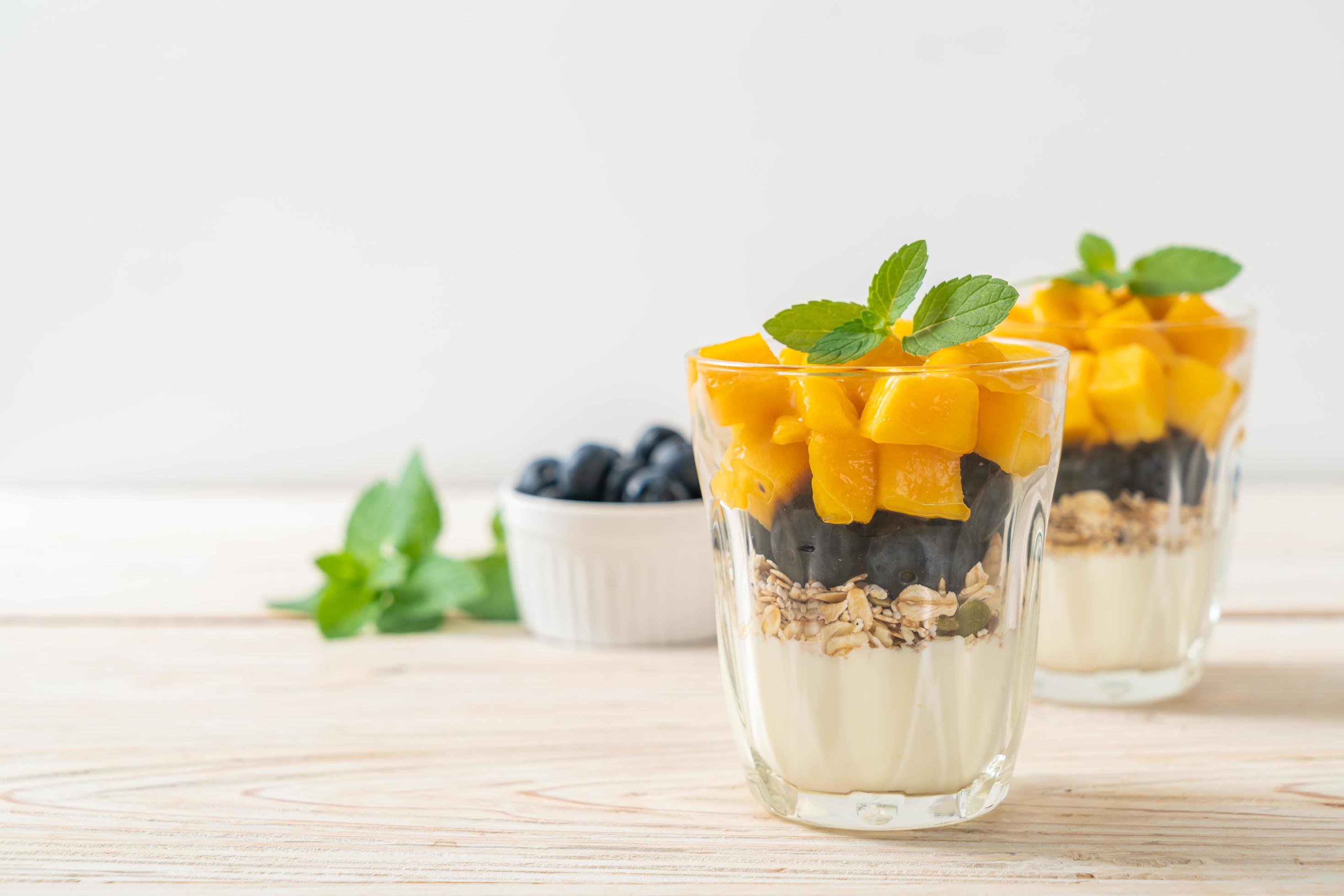 Homemade fresh mango and fresh blueberry with yogurt and granola – healthy food style Stock Free