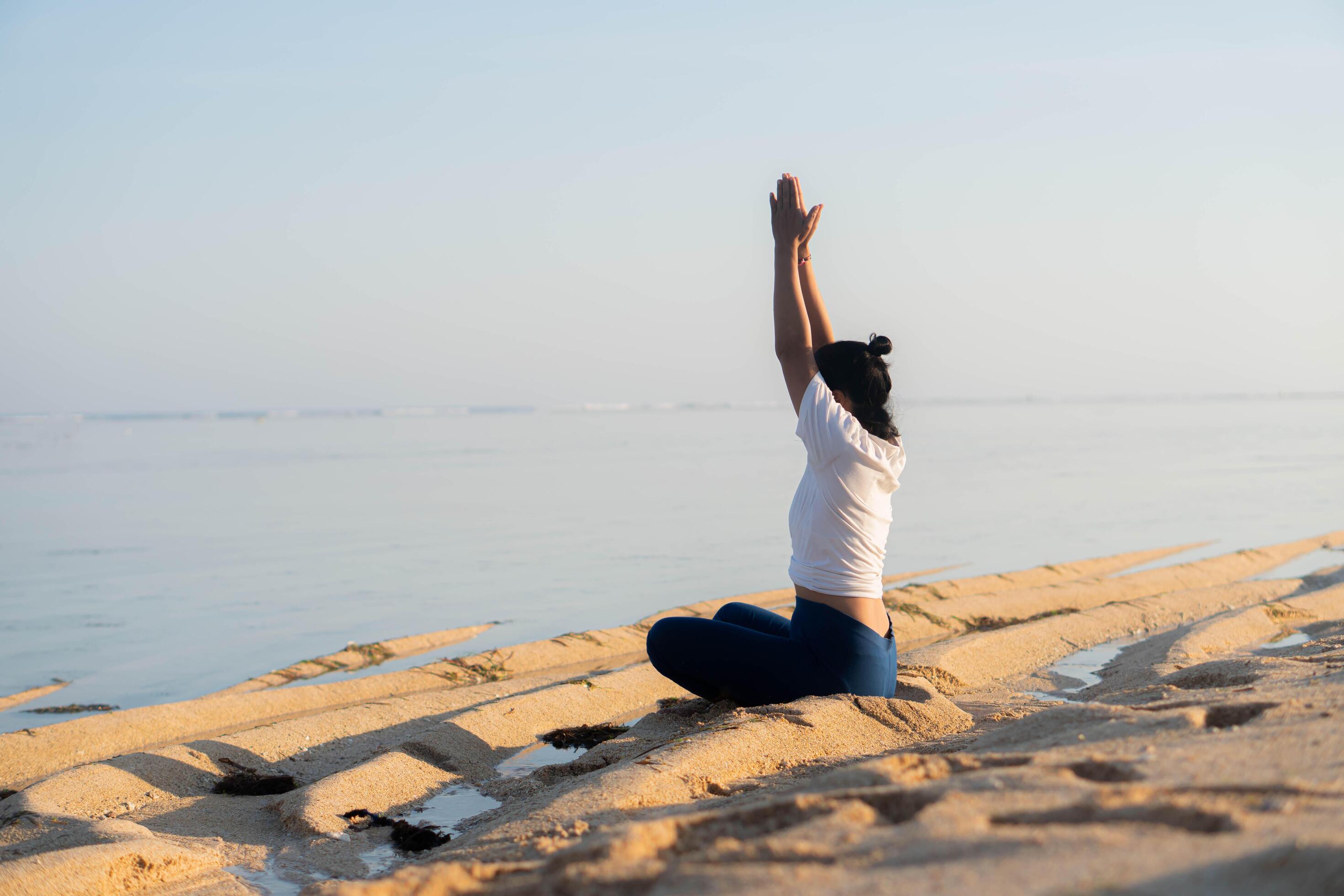 healthy woman with beautiful body doing yoga at sunrise on the beach, yoga poses Stock Free