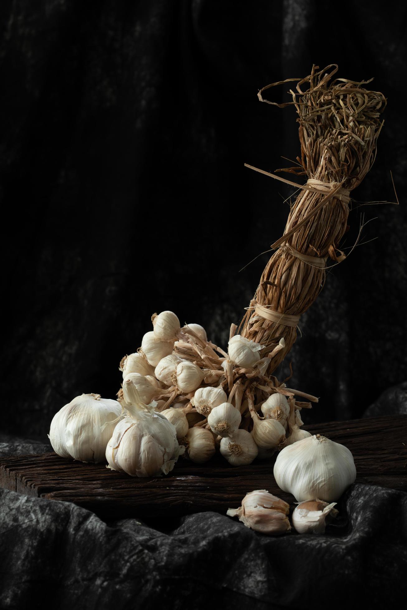 garlic cloves and bulb on vintage wood black cloth Stock Free