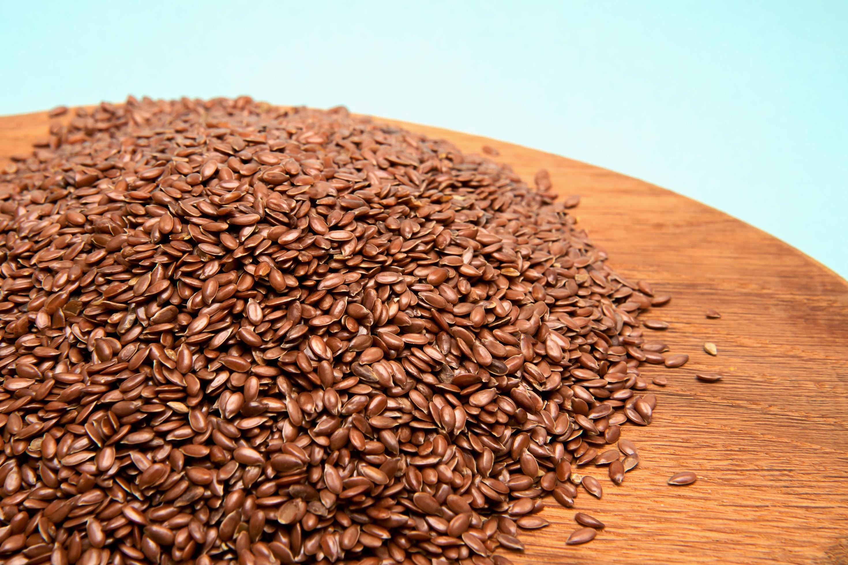 Flax seeds in a pile on a wooden tray. Healthy food concept Stock Free