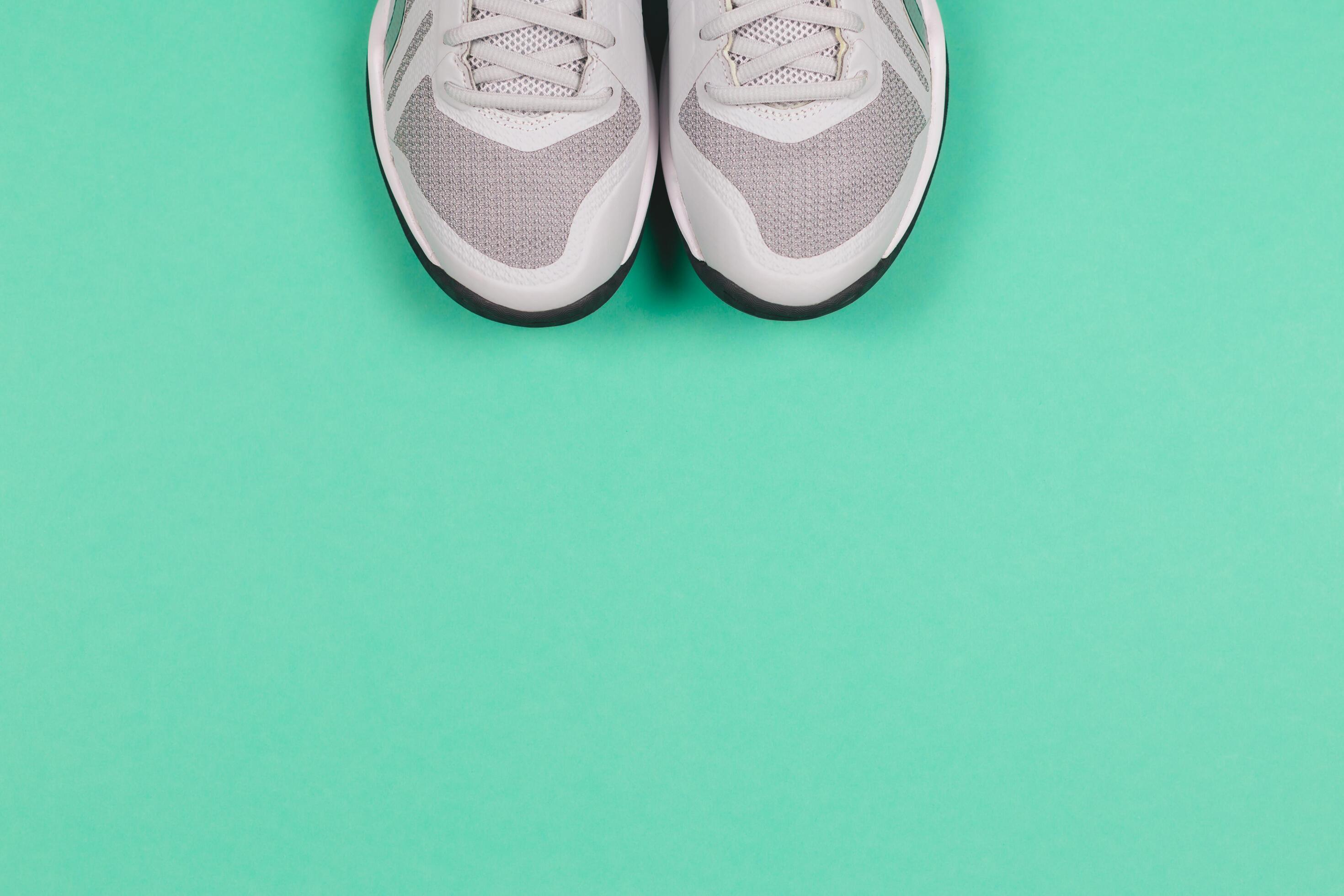 Grey sneakers on the turquoise background. Concept for healthy lifestyle and everyday training. Stock Free