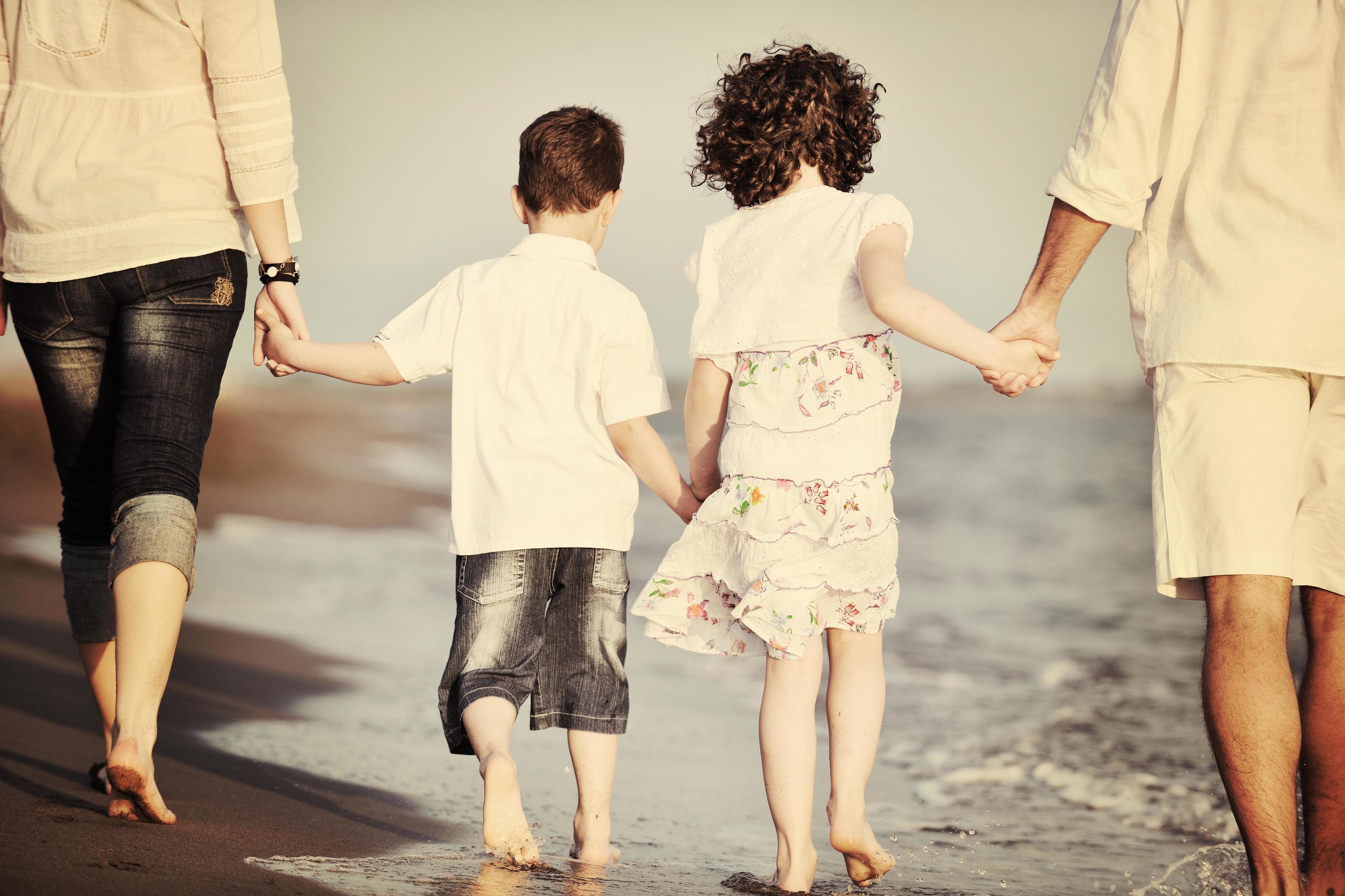 happy young family have fun on beach at sunset Stock Free