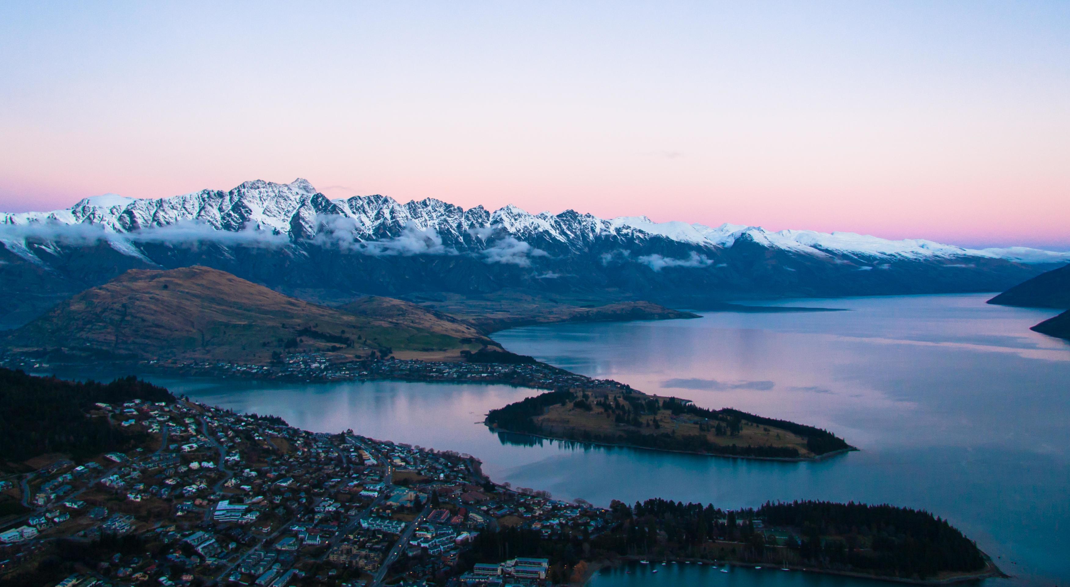 Body of water with city and mountains at sunset Stock Free