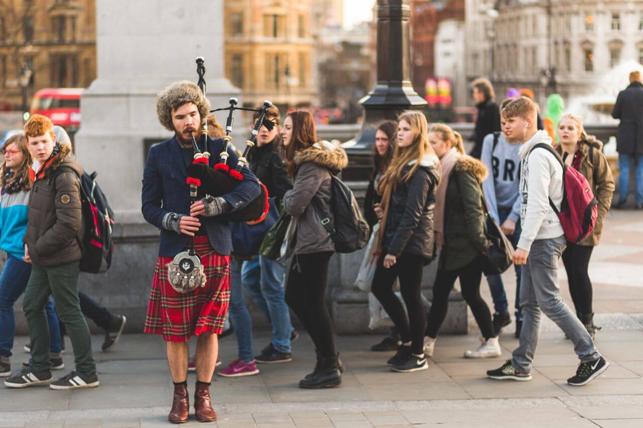 Playing Bagpipes on Crowded Street Stock Free