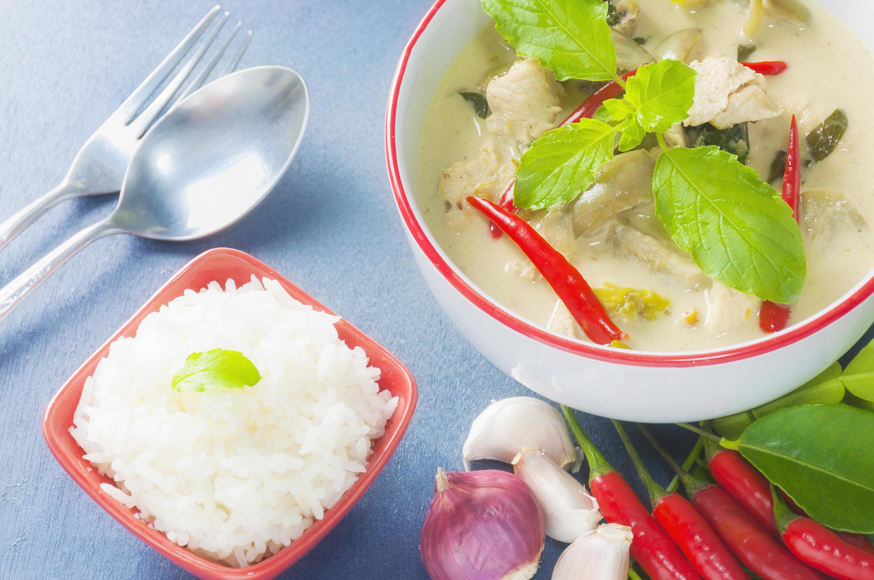 Green chicken curry with raw spicy ingredient and rice with spoon and fork, Thai traditional food Stock Free