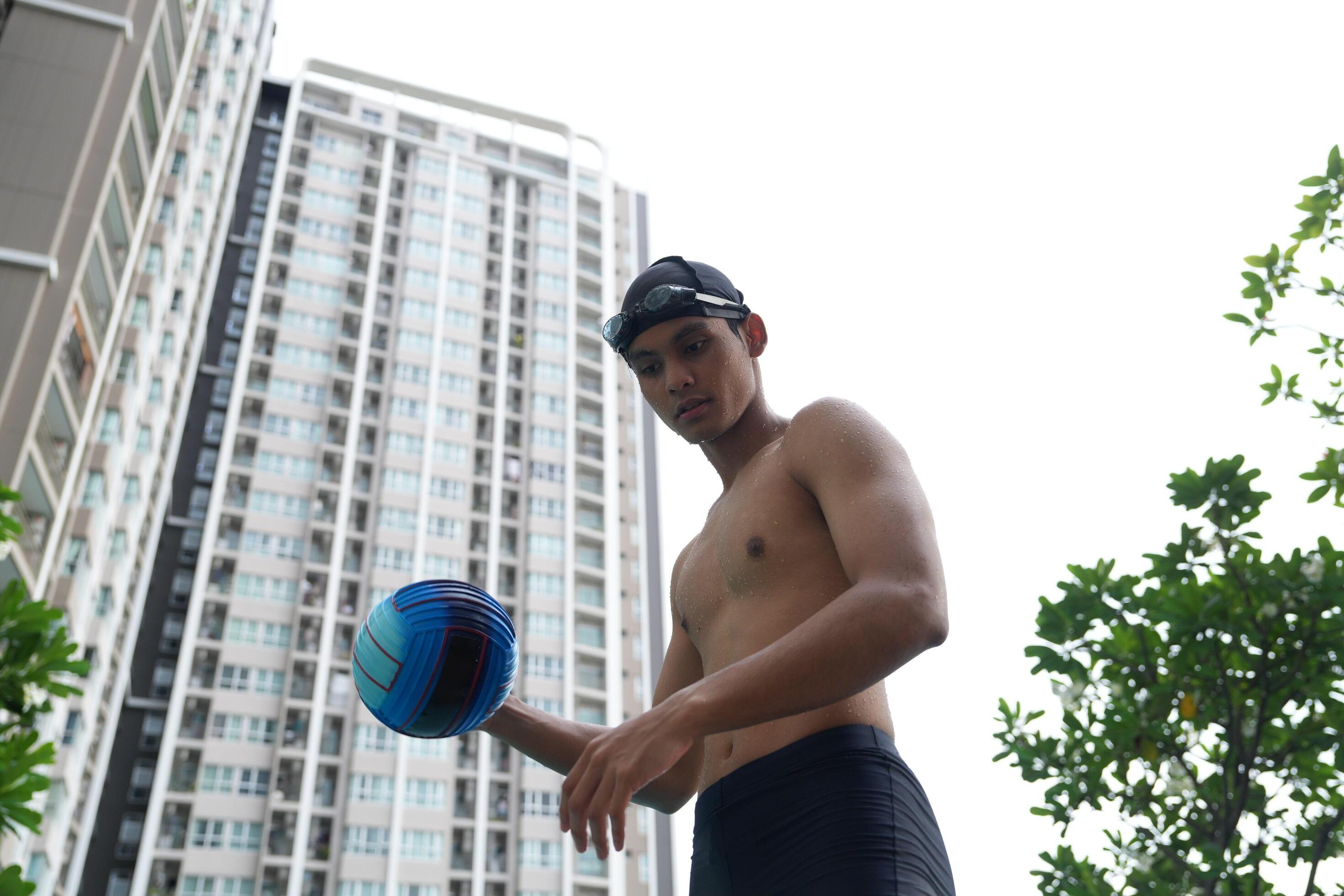 Asian men practicing swimming and preparing to play water polo and stretching and resting for water sports. Stock Free