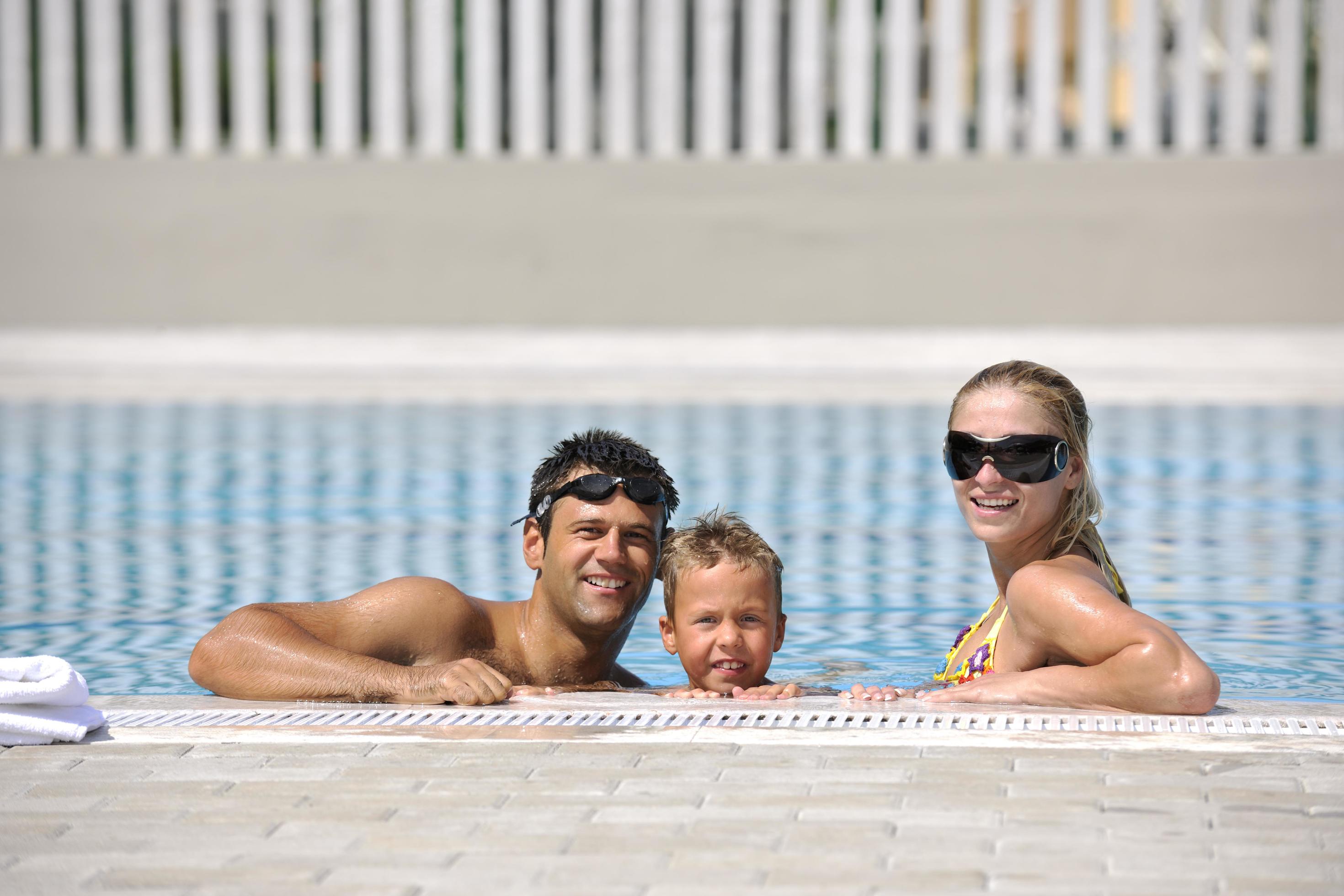 happy young family have fun on swimming pool Stock Free