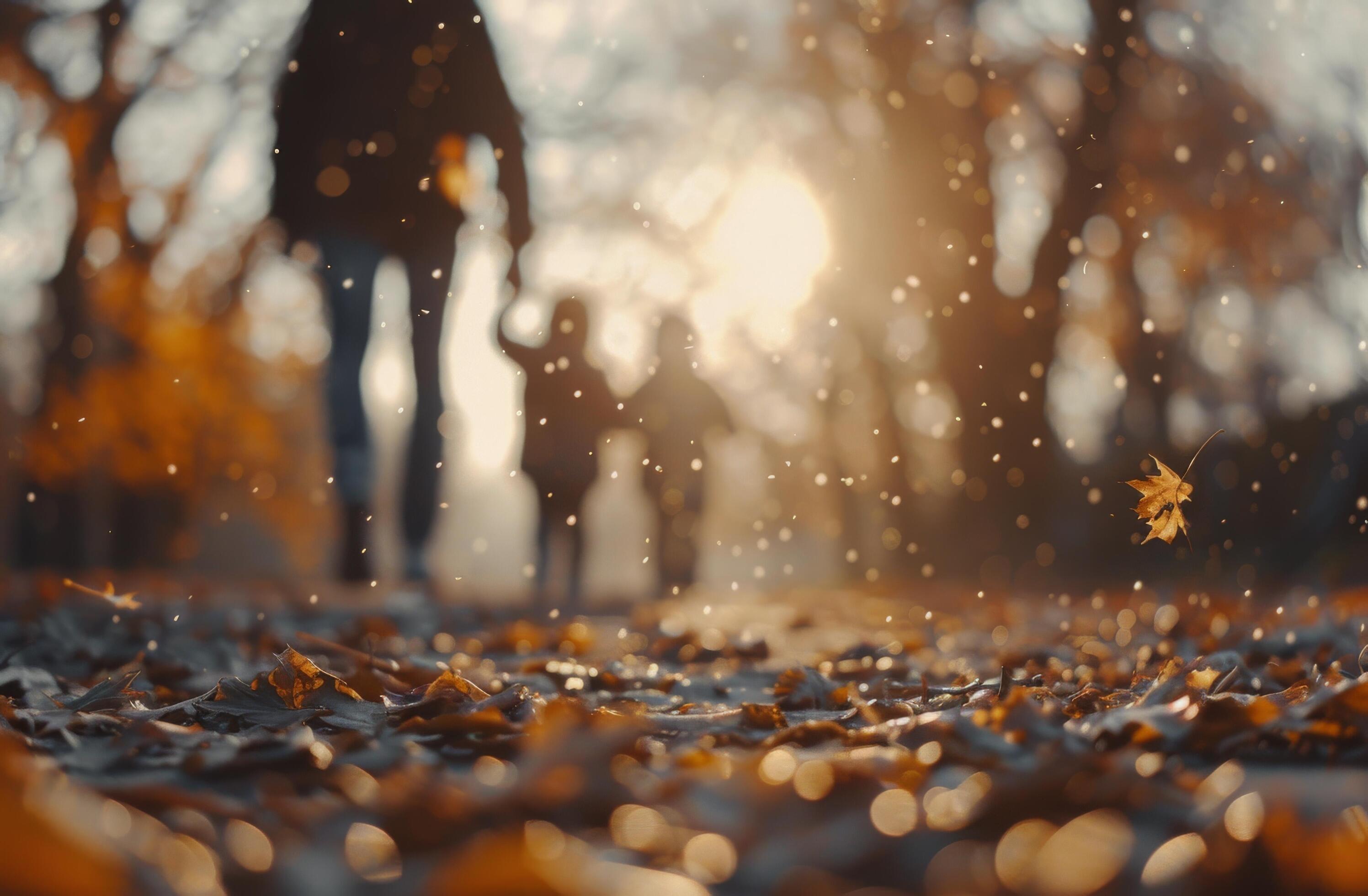 Family Walking Through Autumn Leaves in a Sunlit Park During Golden Hour Stock Free