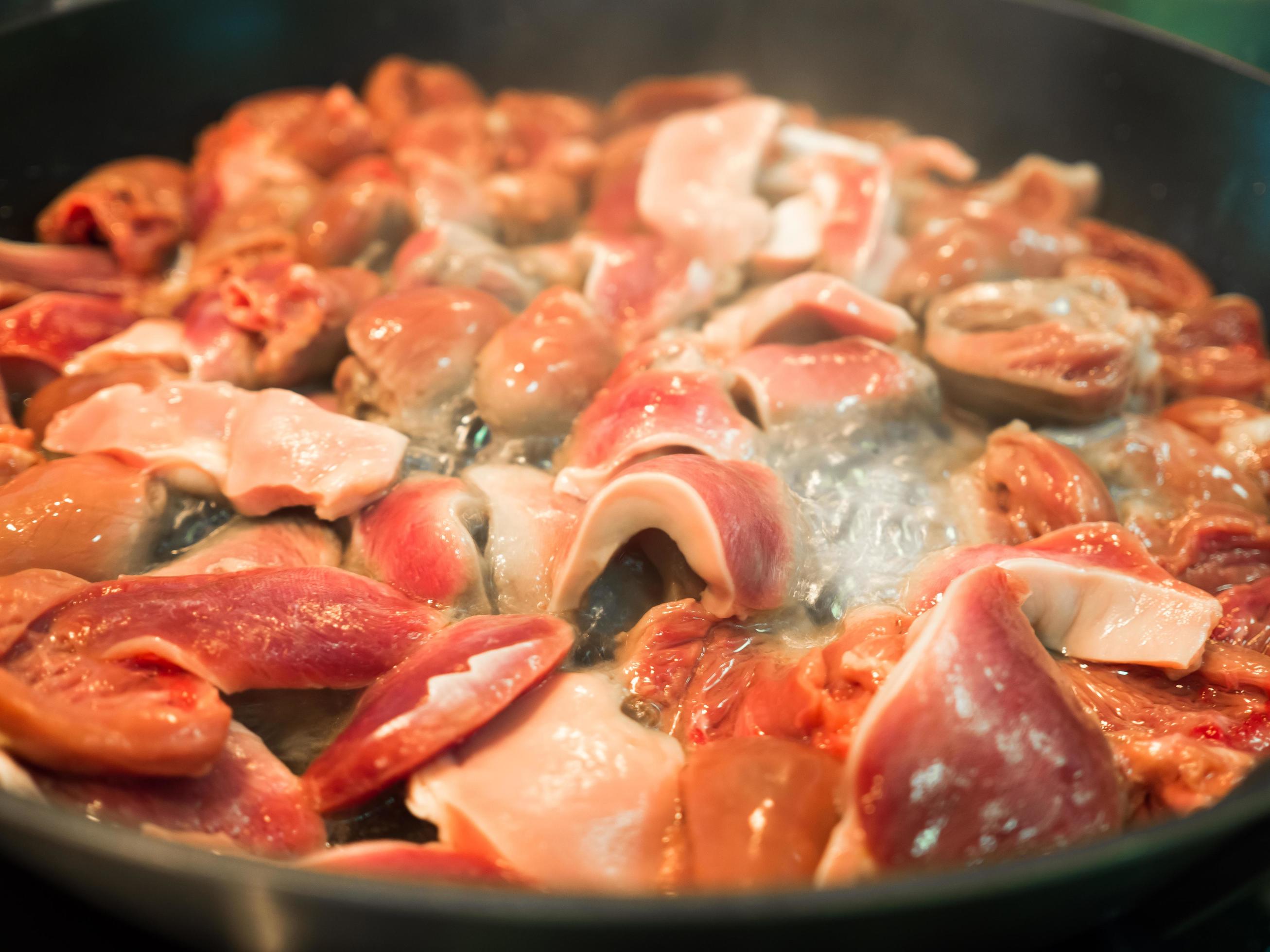 Asian food cooked chicken hearts fried in pan. Stock Free