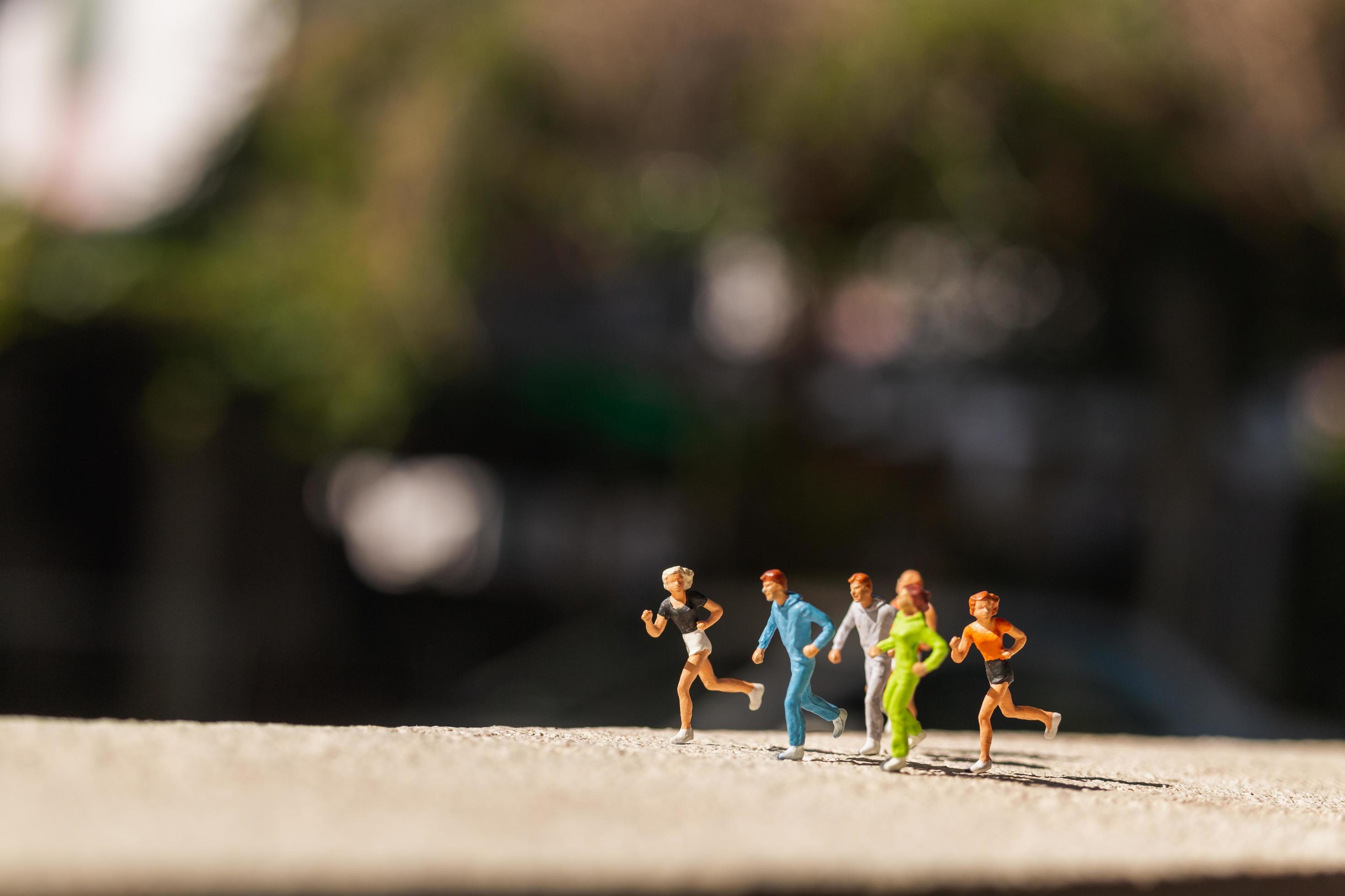 Miniature group of people running on a concrete road, healthy lifestyle concept Stock Free