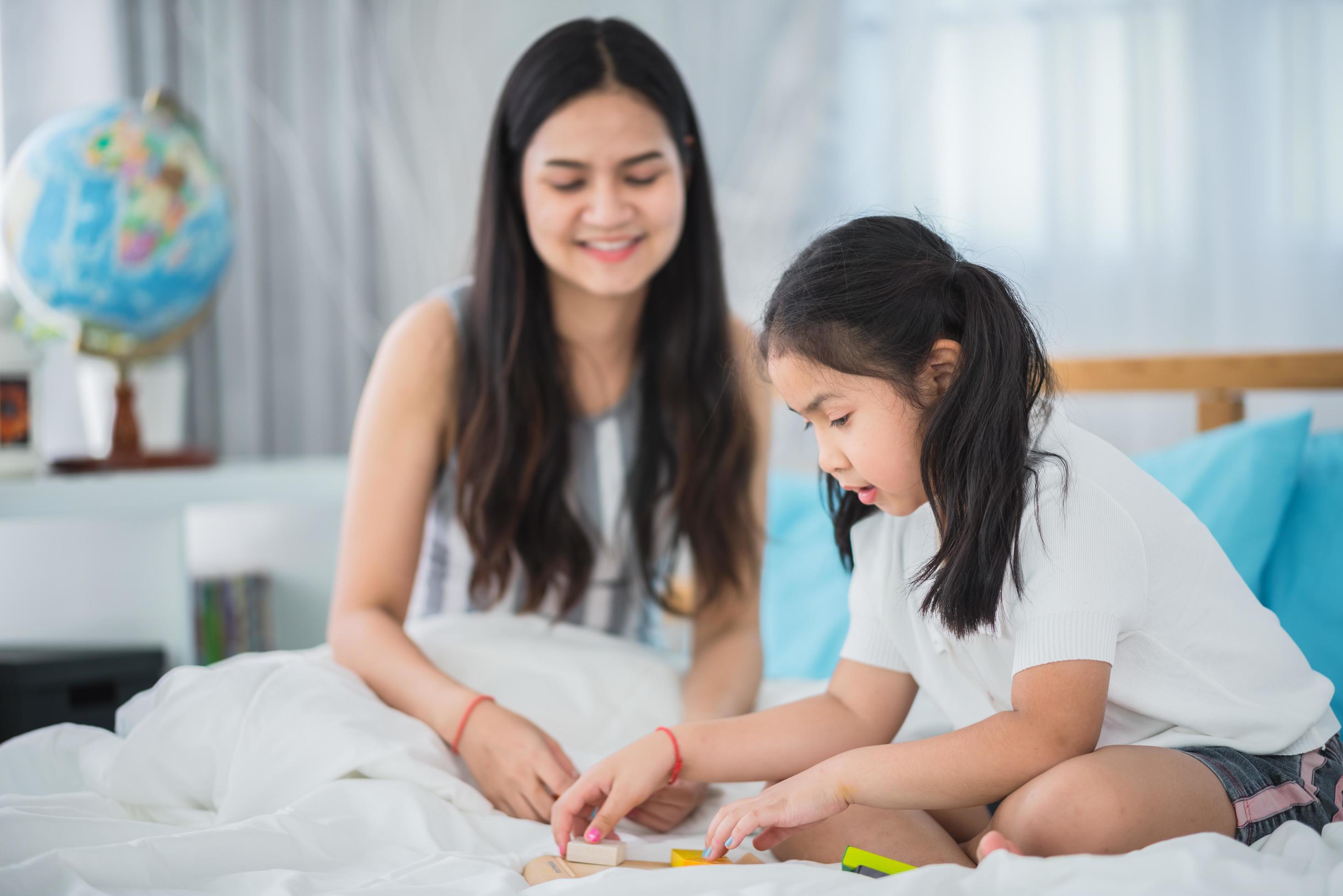 mother teaching child girl for doing homework at home, family education activity concept Stock Free