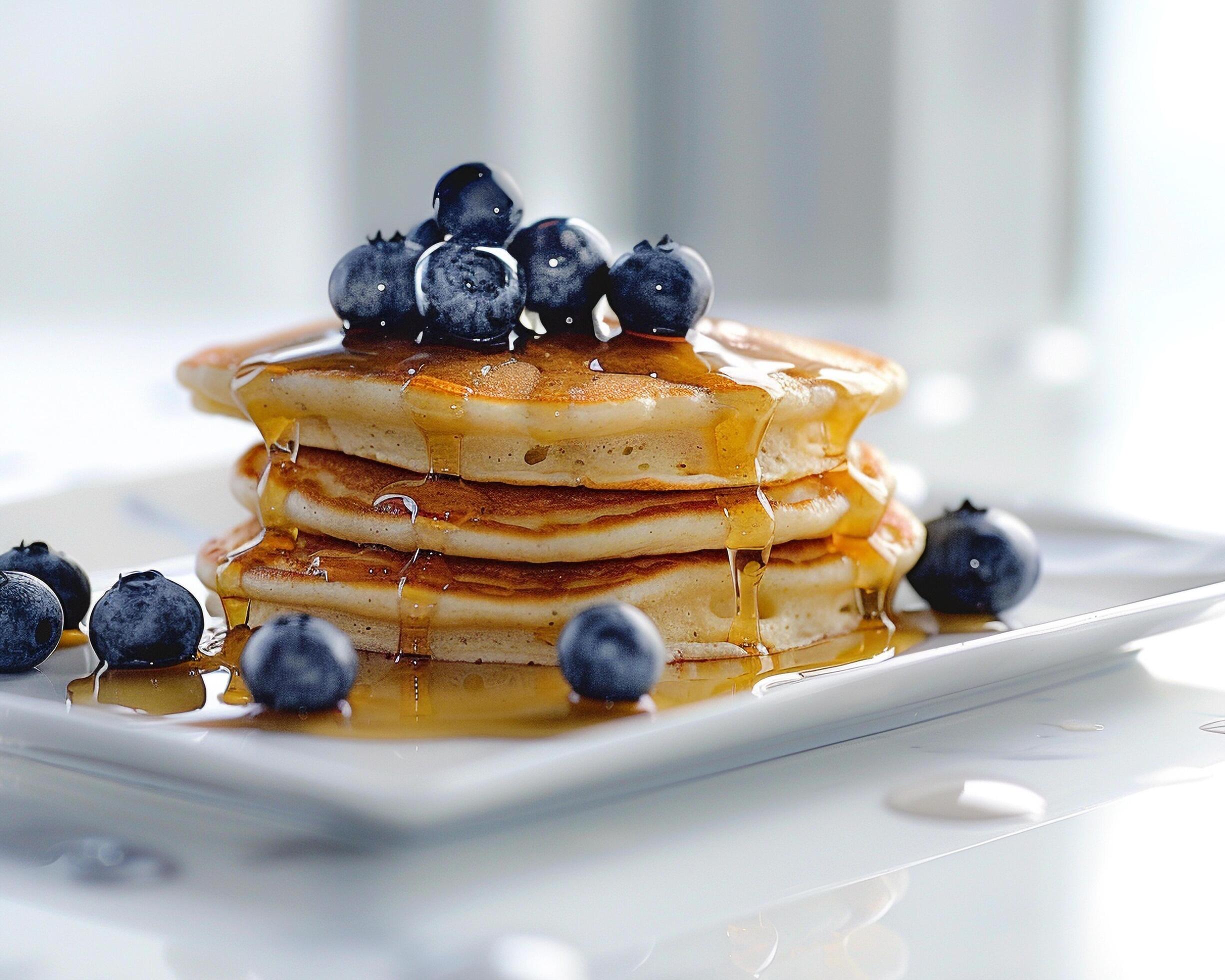 a stack of pancakes with syrup and blueberries Stock Free