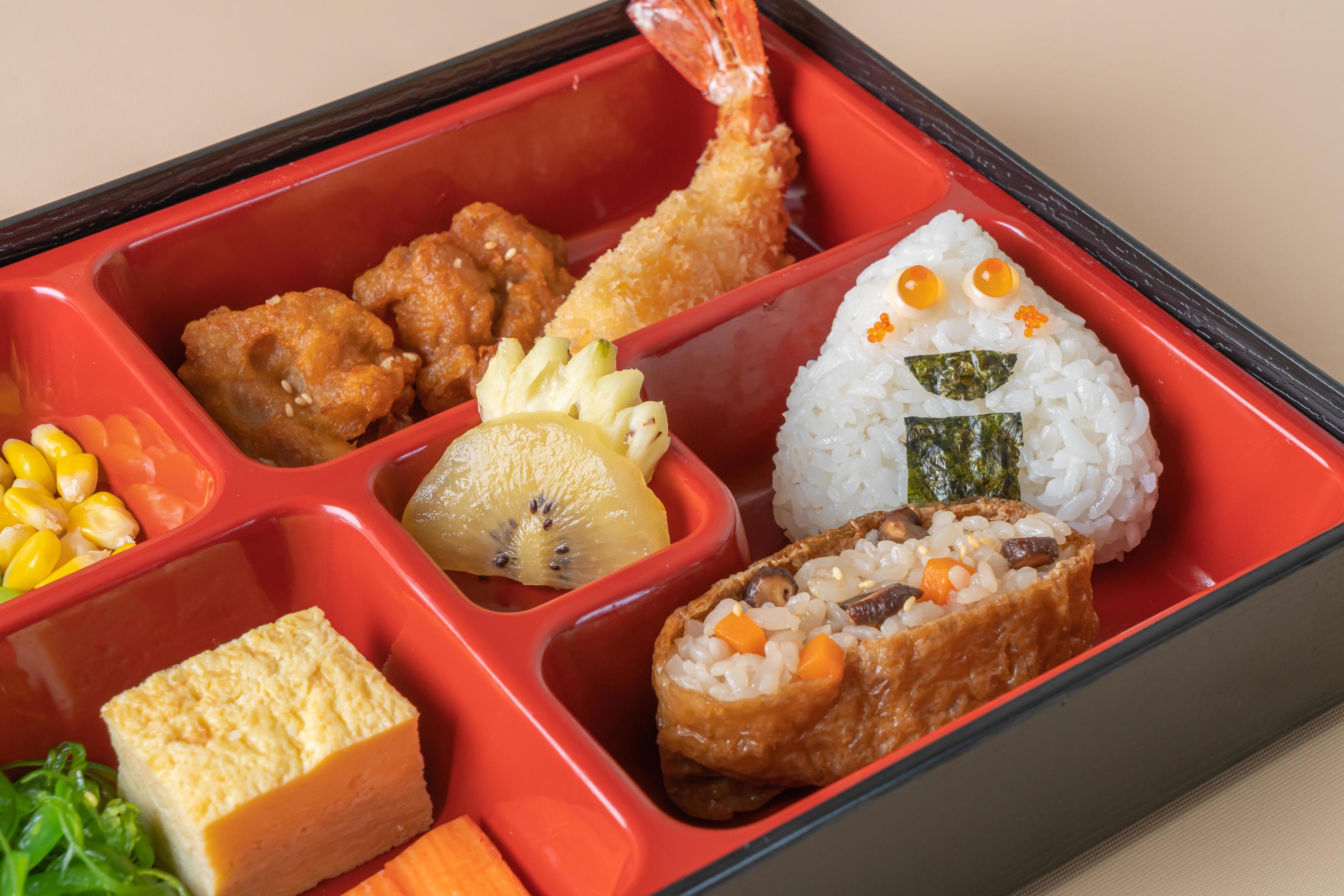 Inari sushi rice wrapped in dried tofu with fried shrimp and fried chicken in bento set – Japanese food style Stock Free