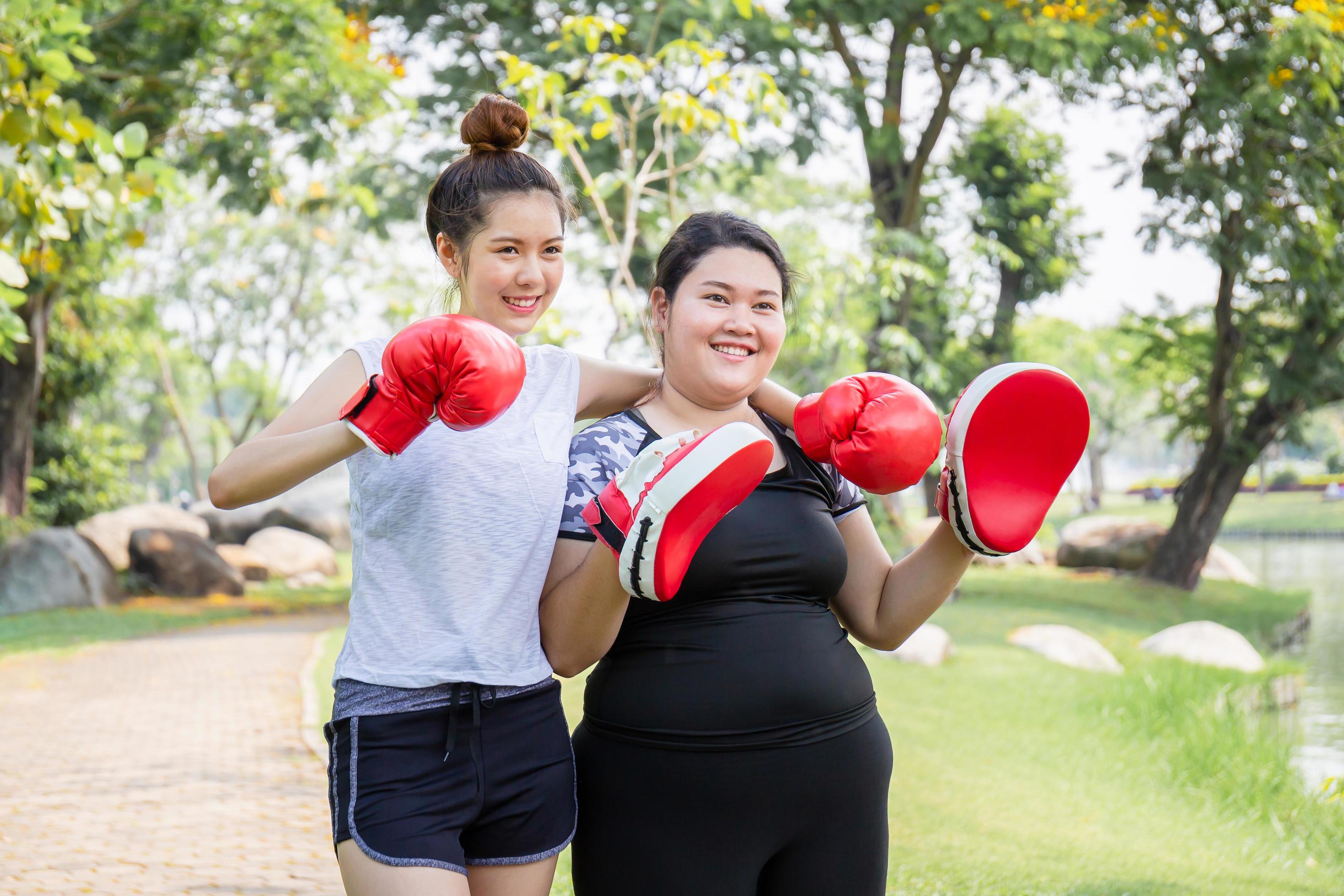 Happy young woman and friend exercising in the park, healthy and lifestyle concepts Stock Free