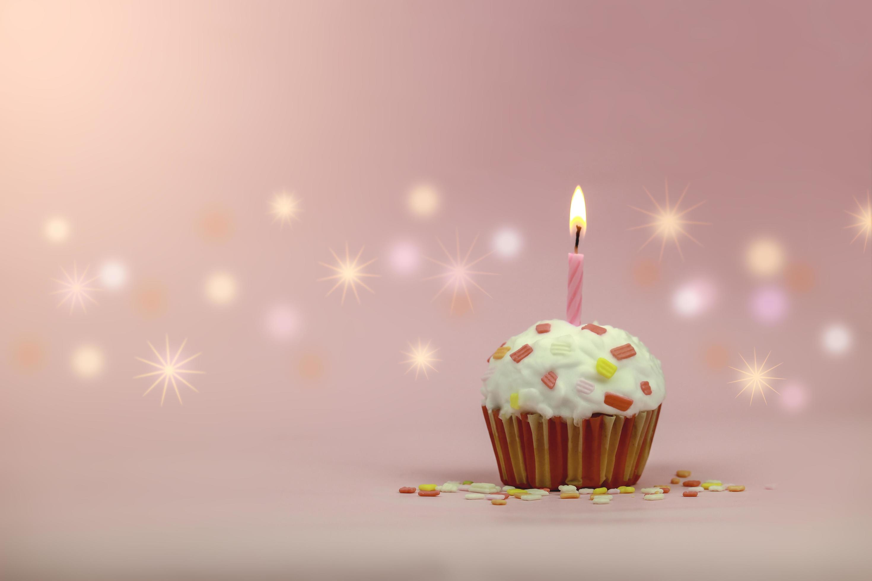 Happy birthday cupcake and bow candle on pink background with copy space. Cute food happy birthday background concept Stock Free