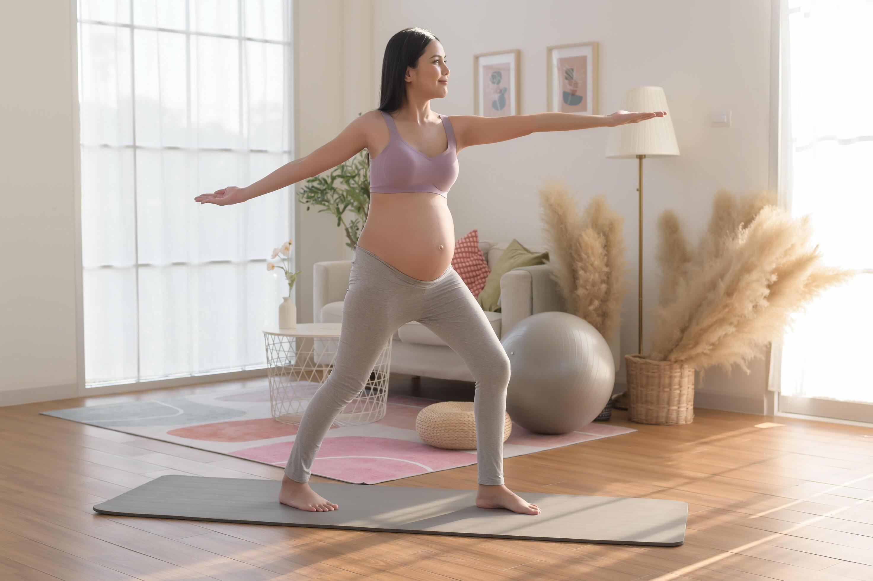 Healthy pregnant woman exercising and doing prenatal yoga, meditation, working out, yoga, pregnancy concept. Stock Free